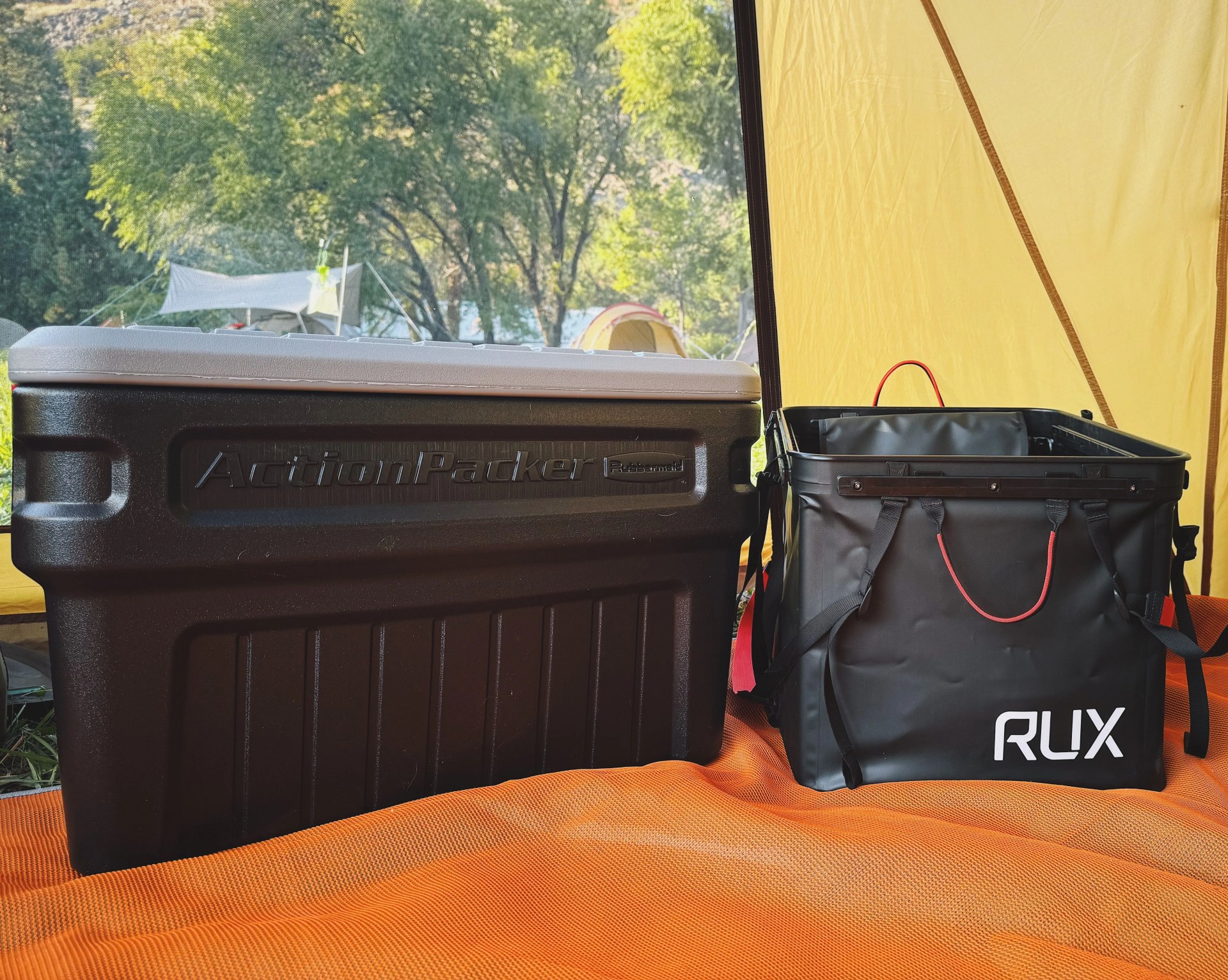 a larger hard sided rubbermaid actionpacker crate sitting next to the softer sided rux 70l