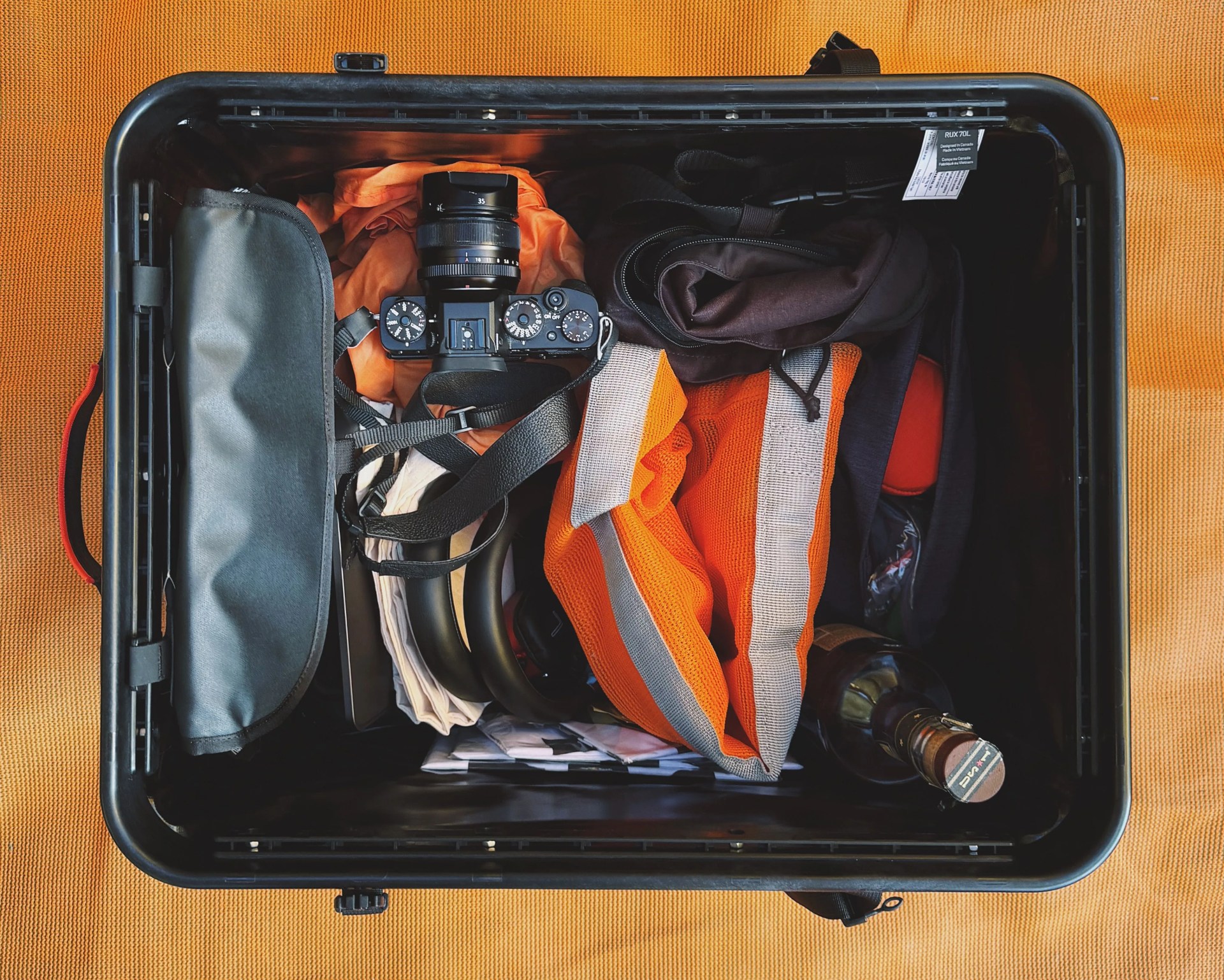 a rux 70l packed with fragile contents including a camera and bottle of bourbon