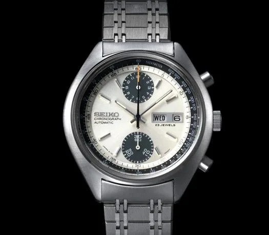 a silver watch with a black face