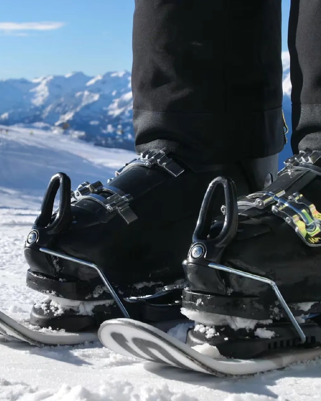 a person wearing skiskates ski boots on the snow