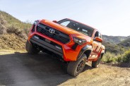 orange tacoma on a dirt road
