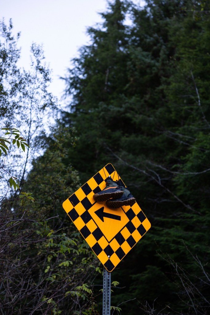 vans sneakers hanging on checkered road sign