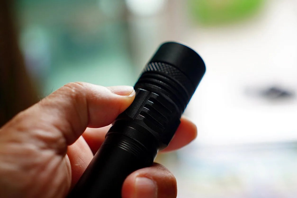 a person holding a black flashlight
