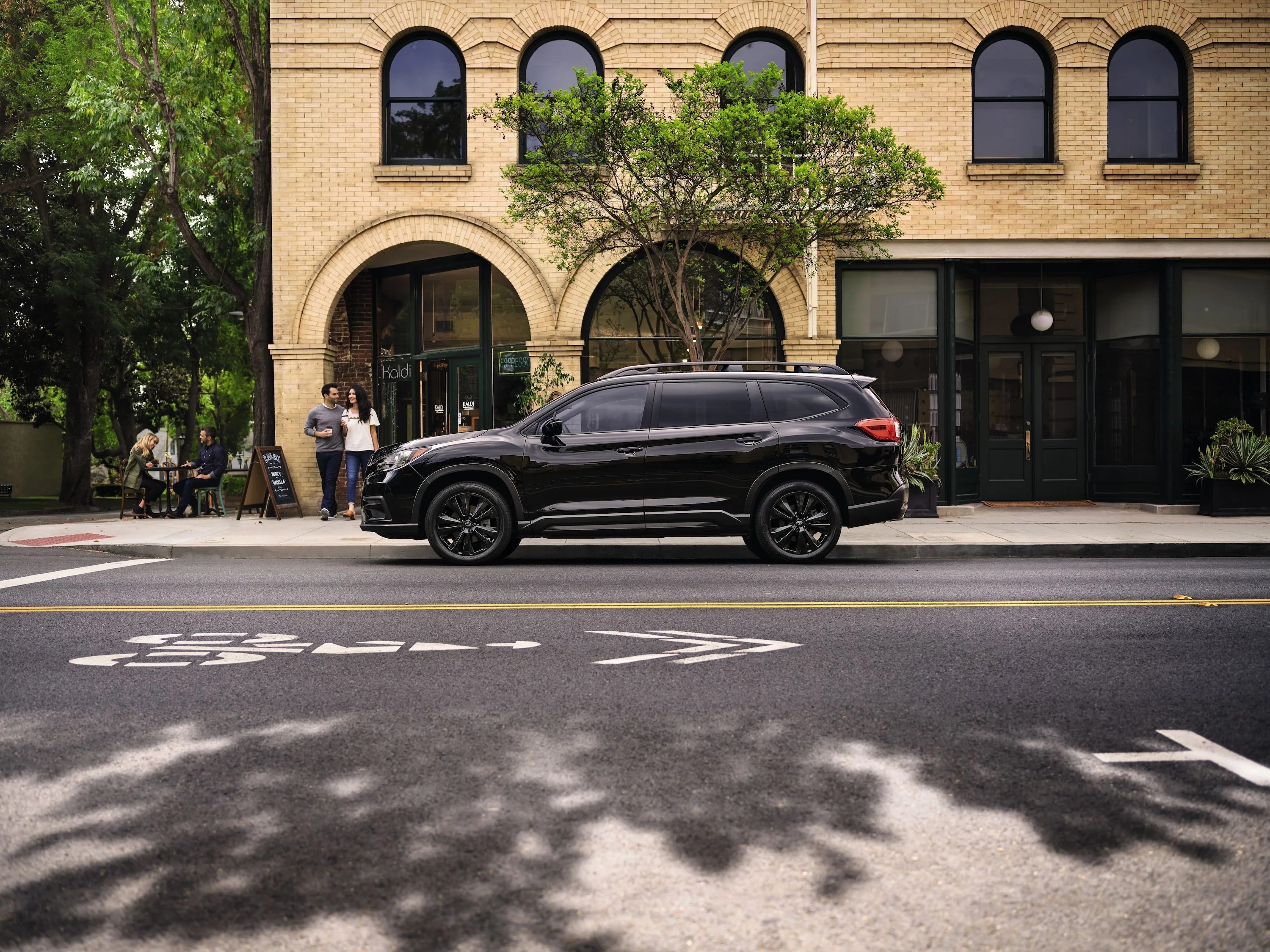 a black car parked on the side of a street