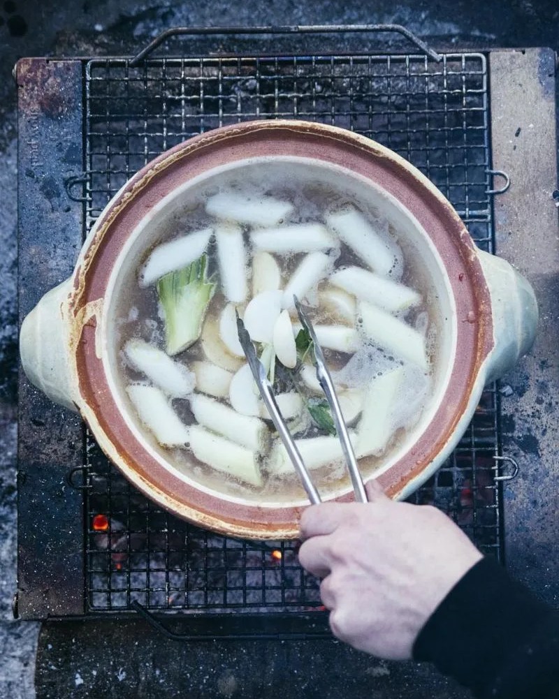 cooking soup on a ceramic pot over a fire