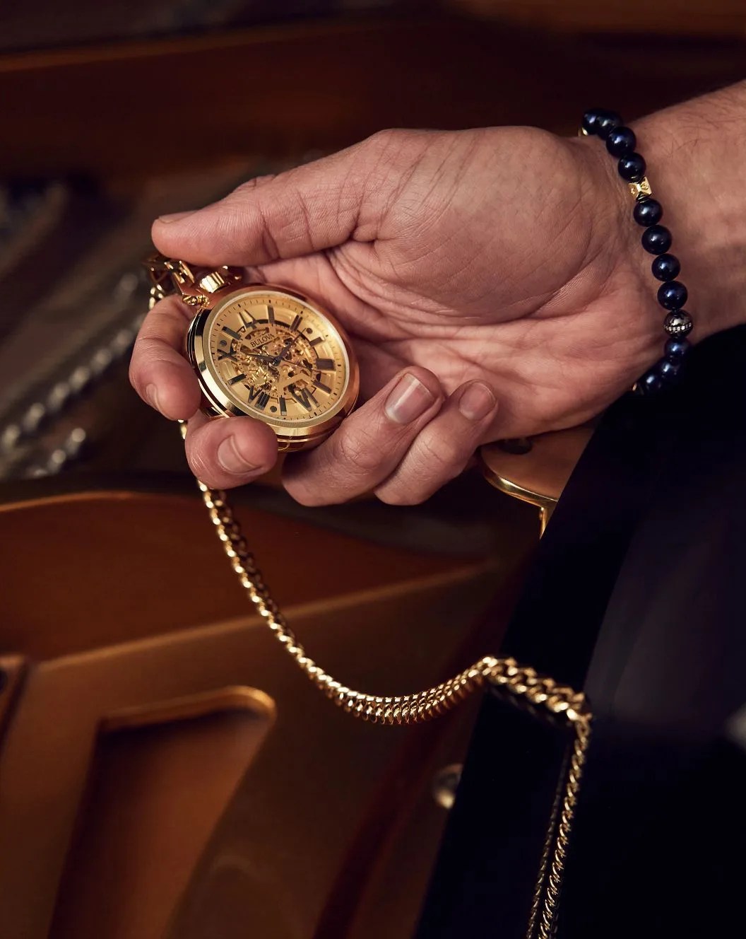 a person holding a bulova sutton pocket watch