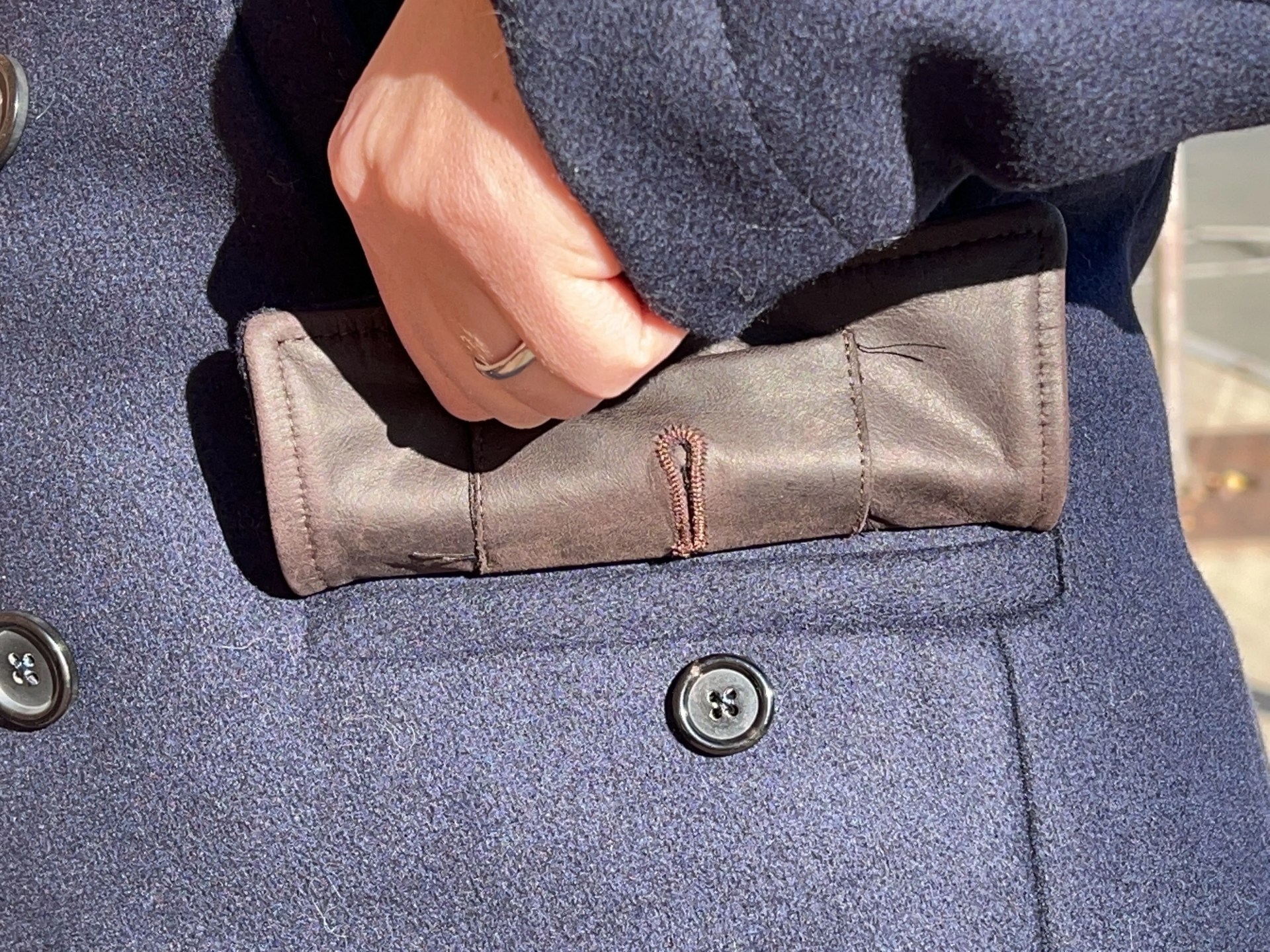 a hand opening a coat pocket