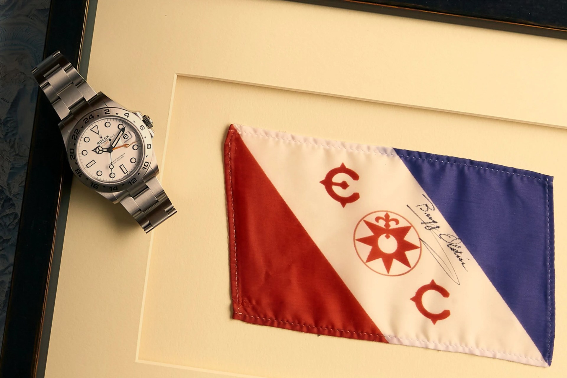 a watch lying on a frame with a signed flag