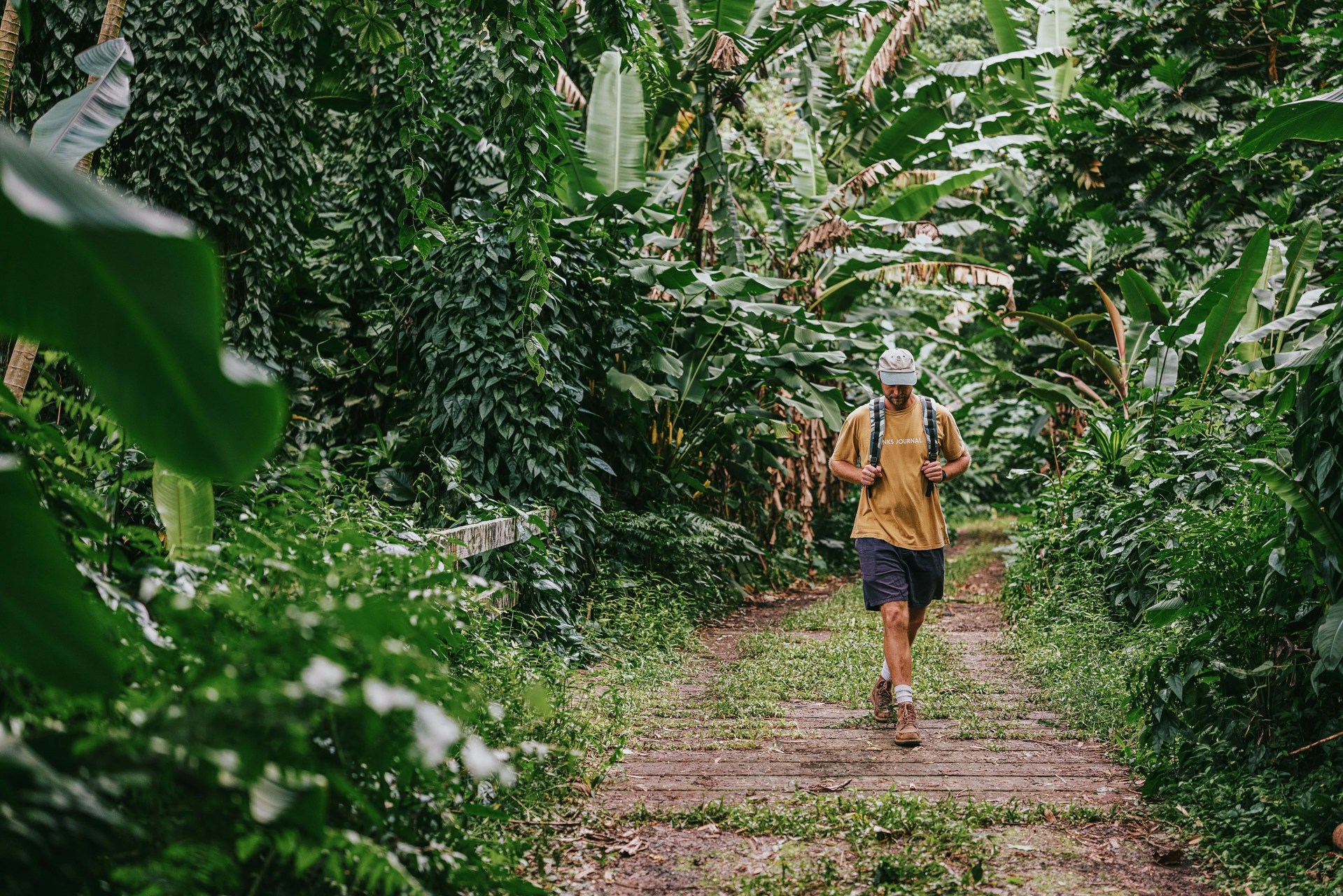 man walking through forest wearing goruck bag