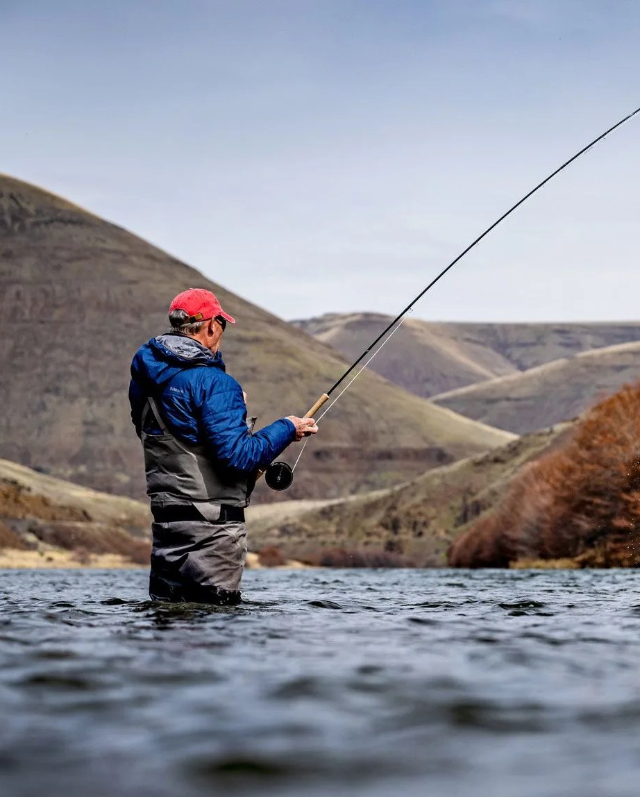 a man fishing in a river with the microspey air 2 rod