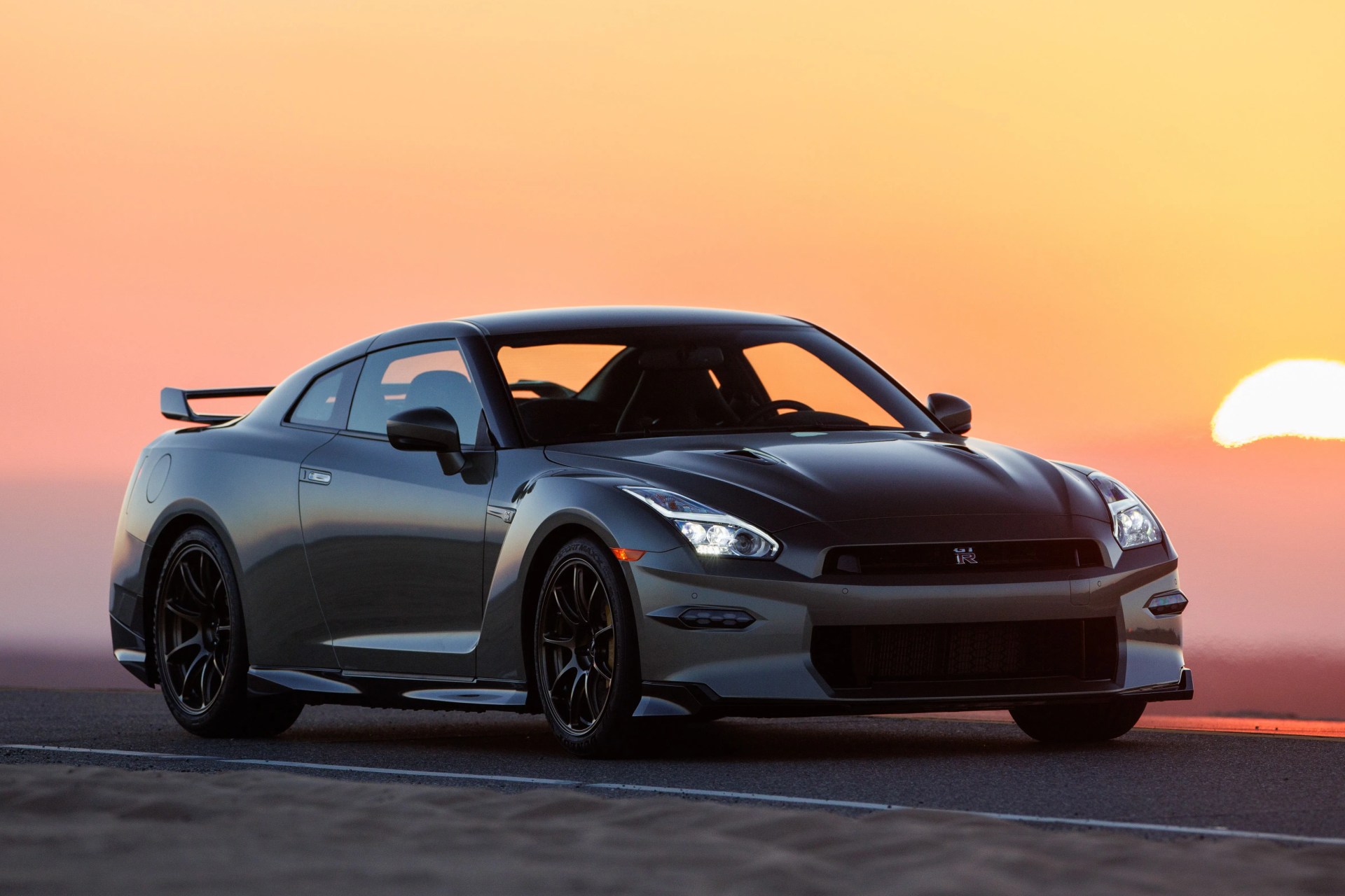 a car on a road in front of a sunset
