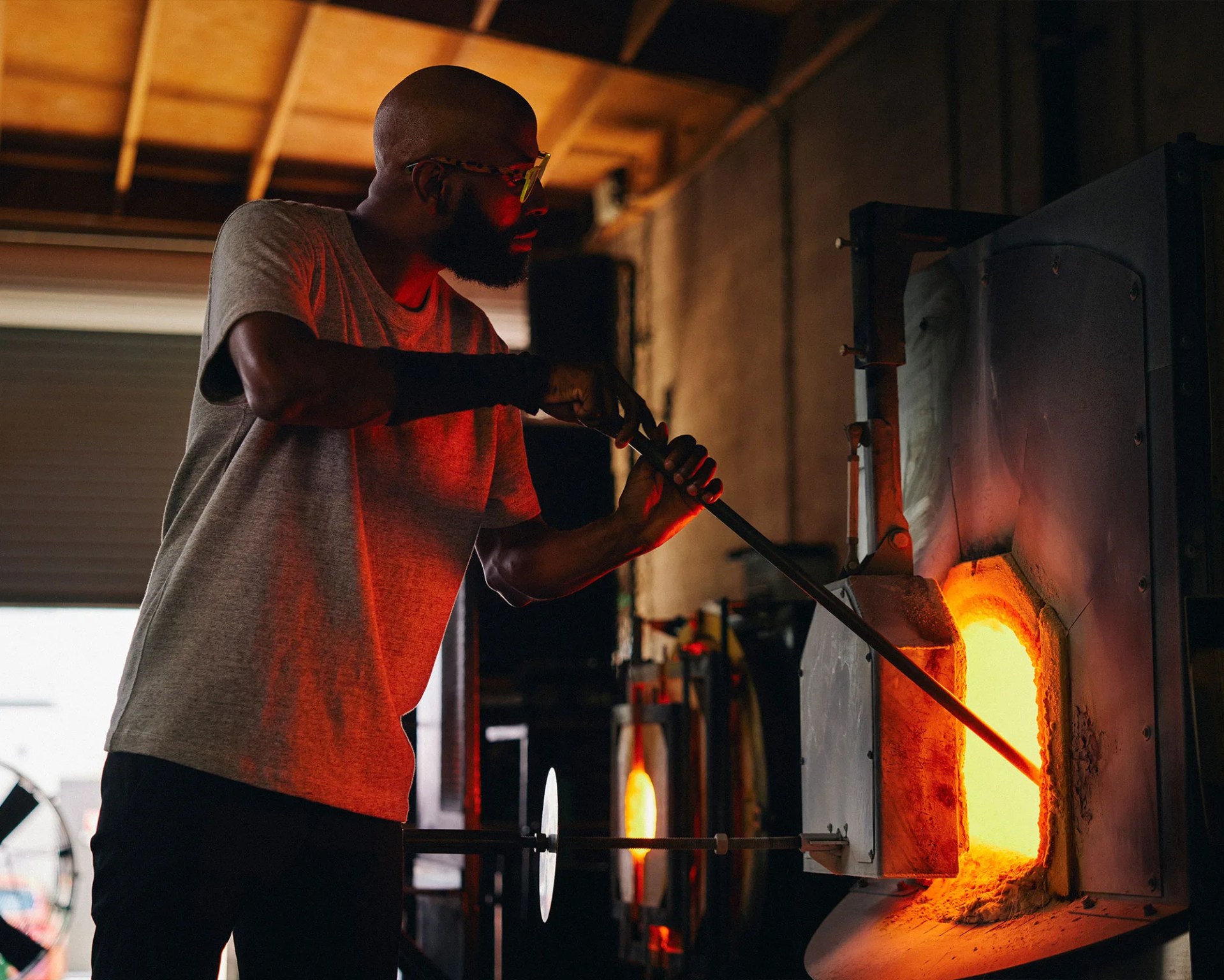 Cedric Mitchell heating up glass in the furnace