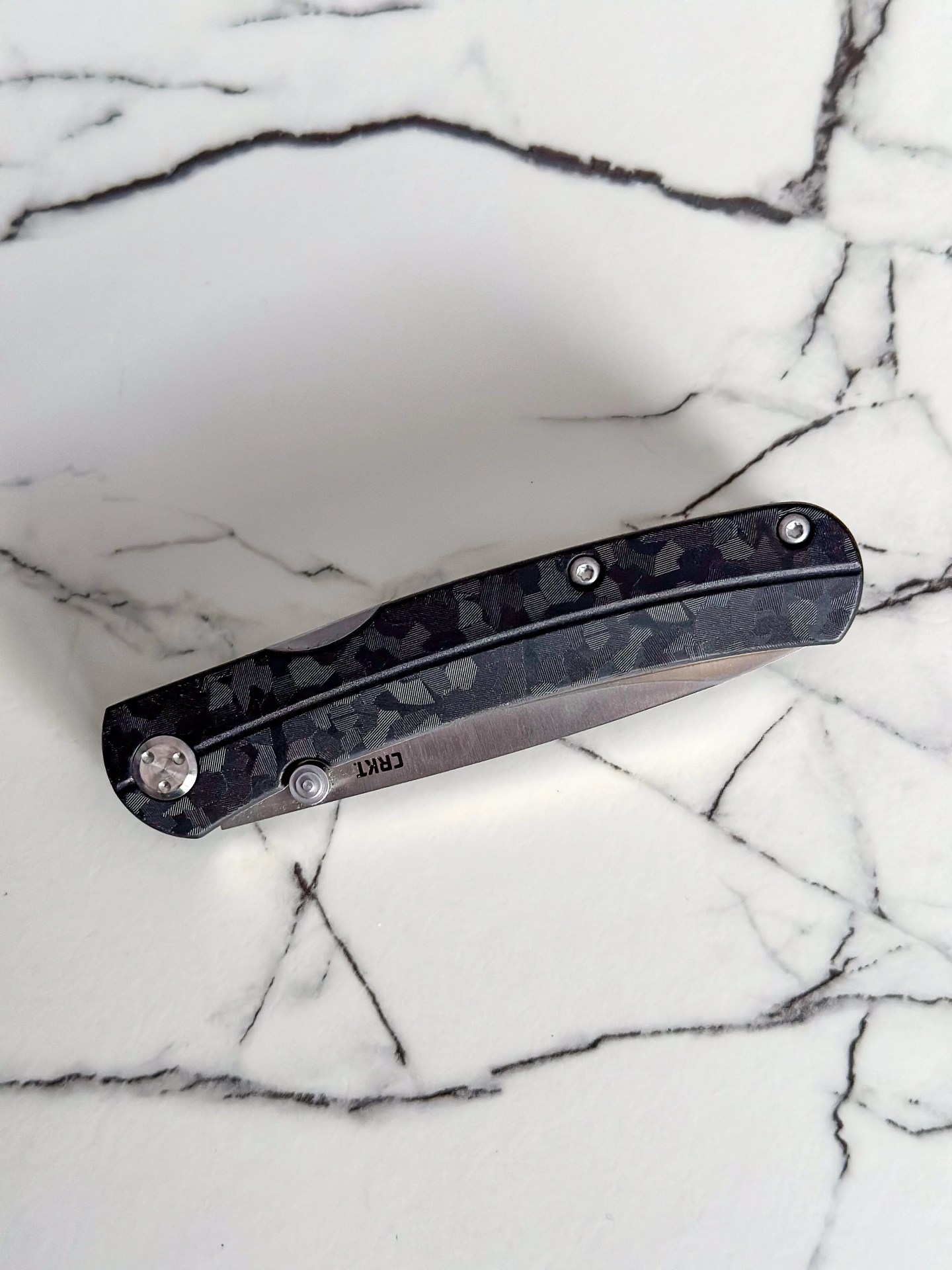 a gray and silver knife on a marble counter