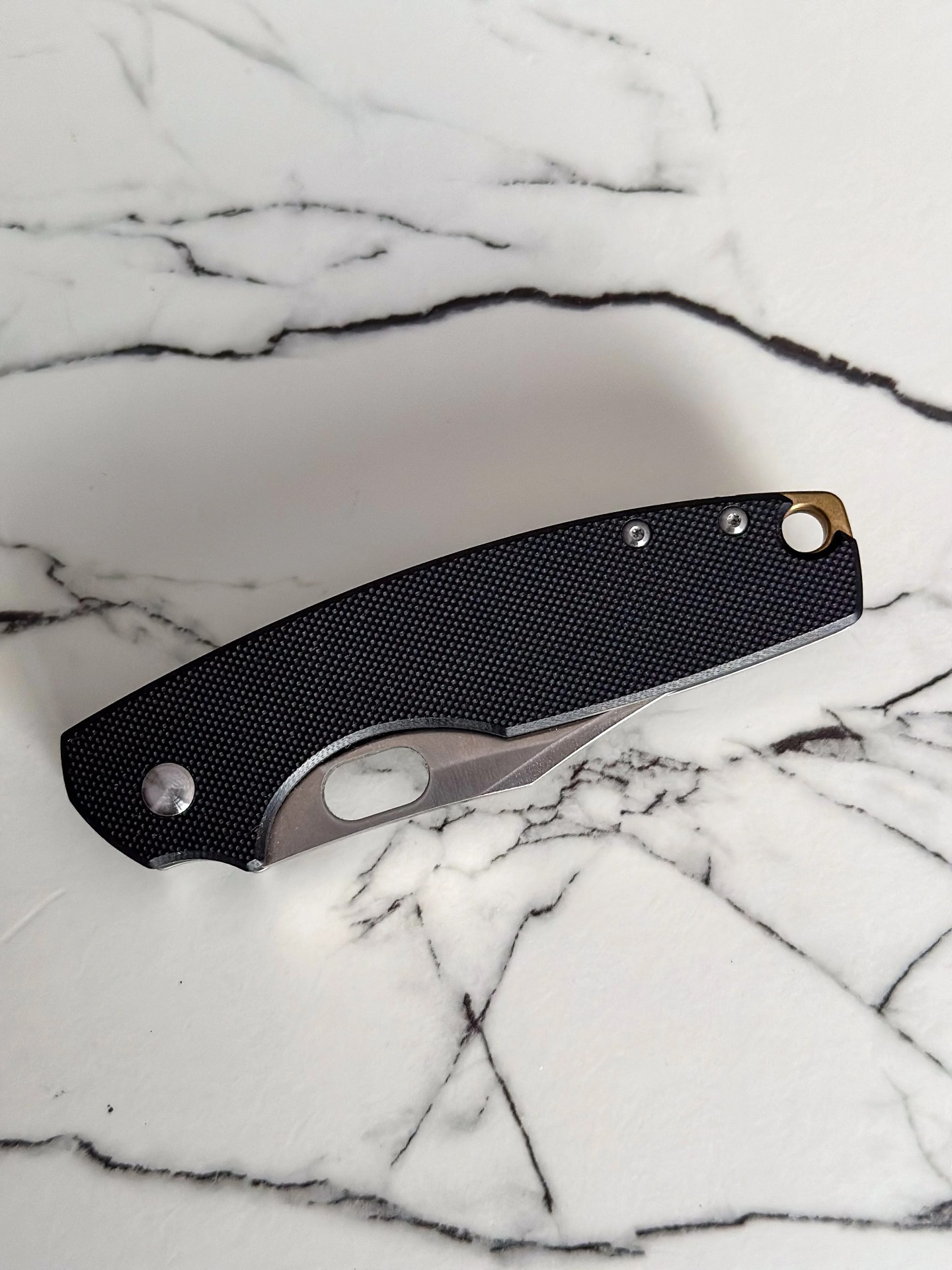 a black and silver knife on a marble counter