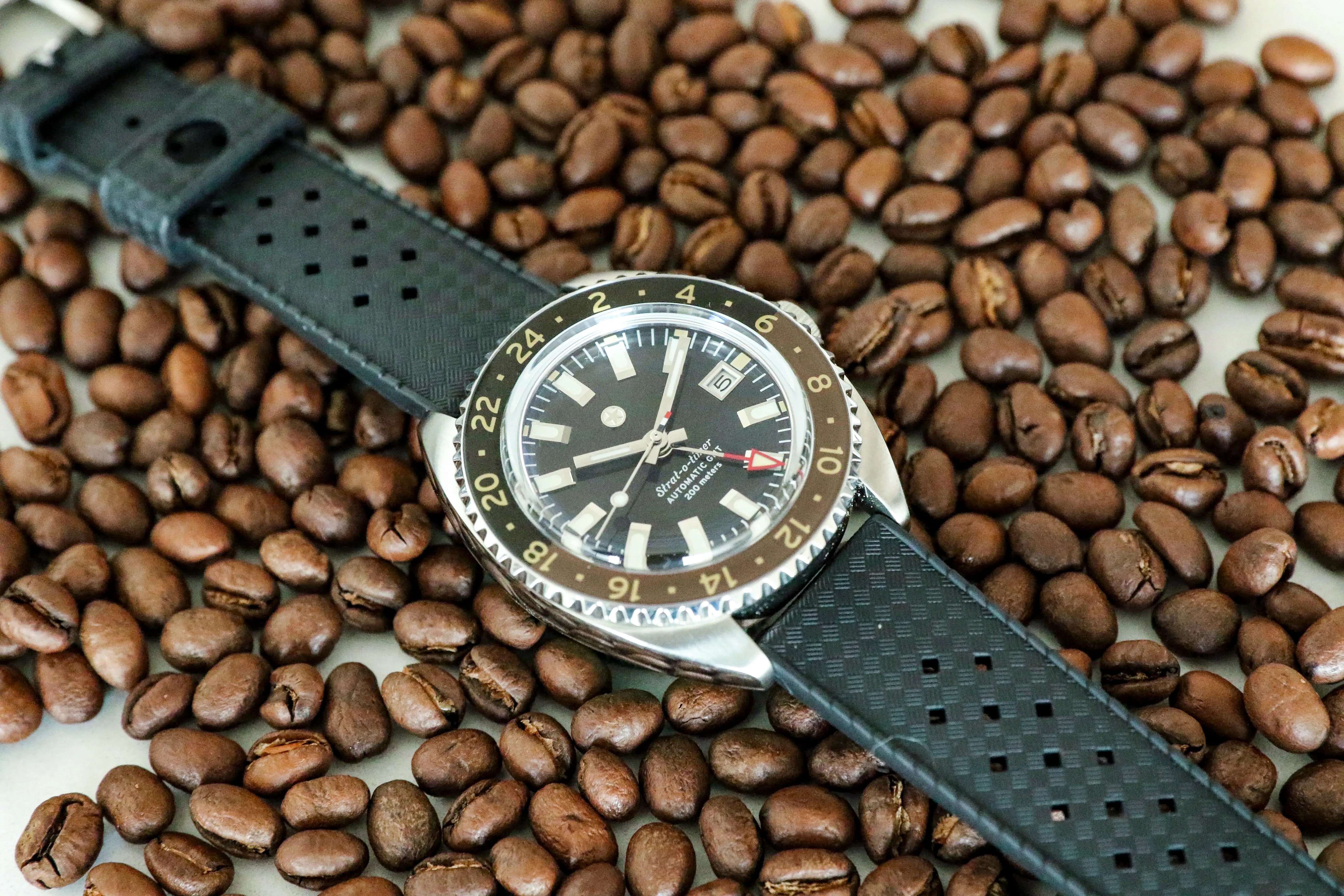 Jack Mason Strat-o-timer GMT watch on a table with coffee beans