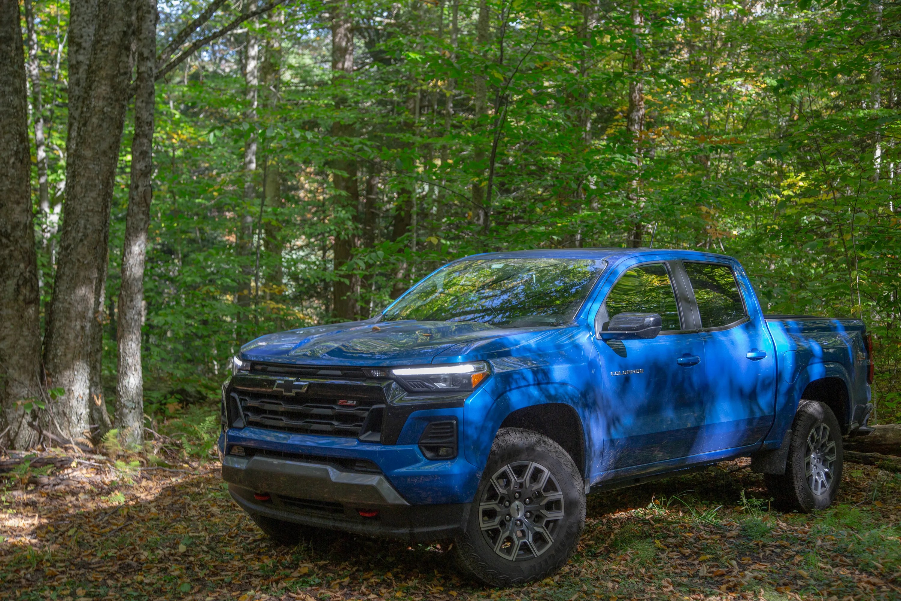 blue 2023 chevrolet colorado z71 in a forest
