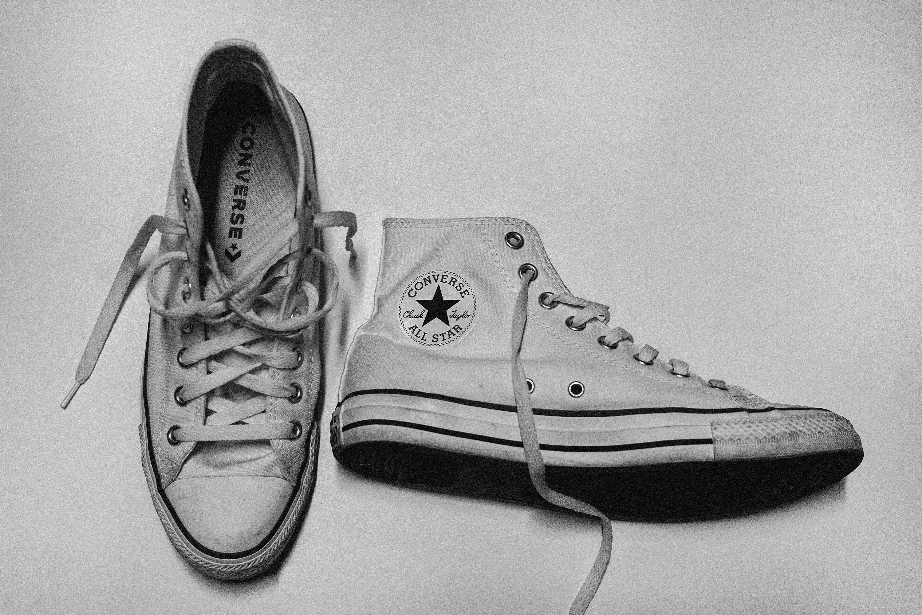 a black and white photo of converse high top shoes