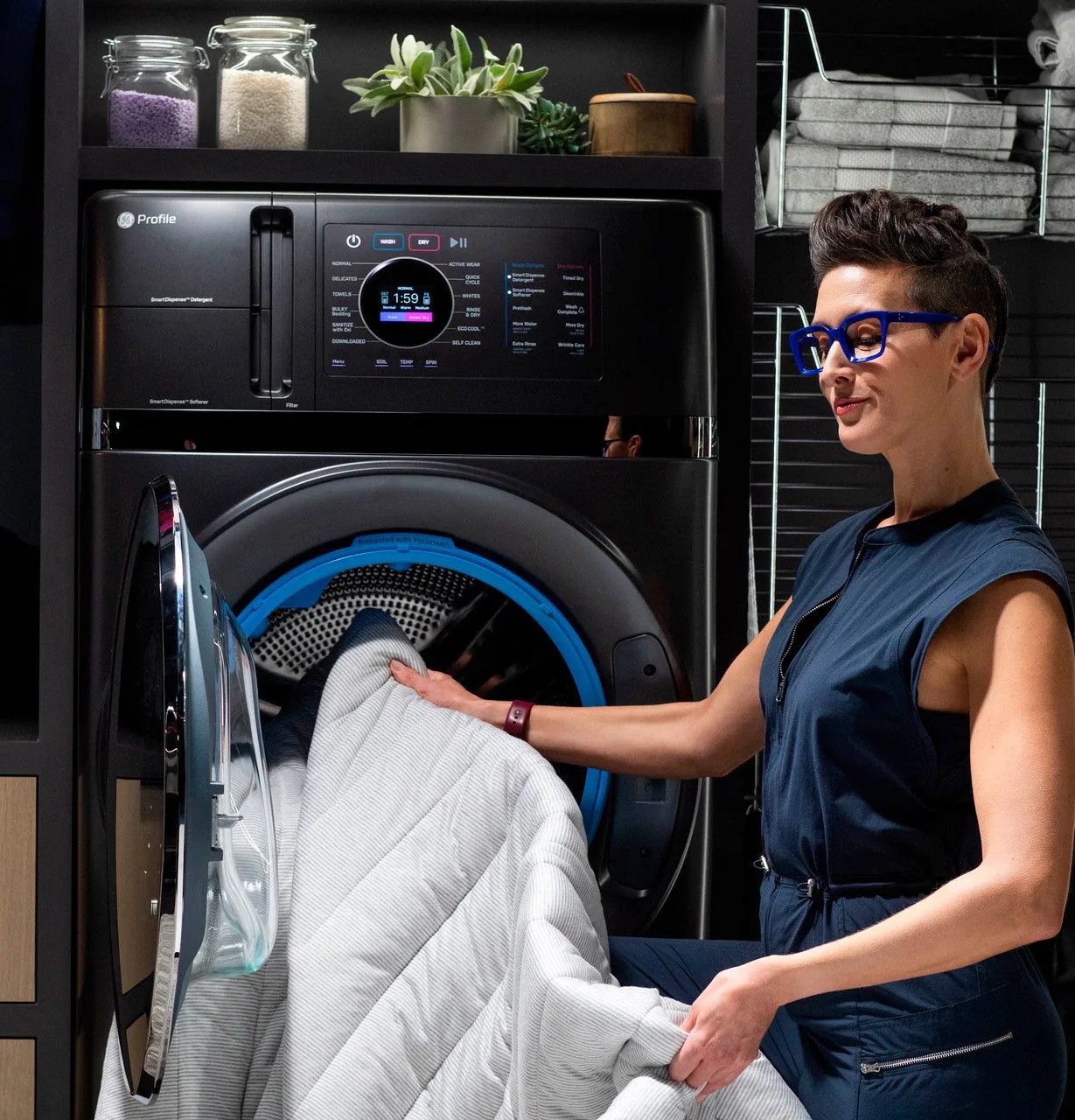 woman loading bedding into ge profile energy star washer dryer
