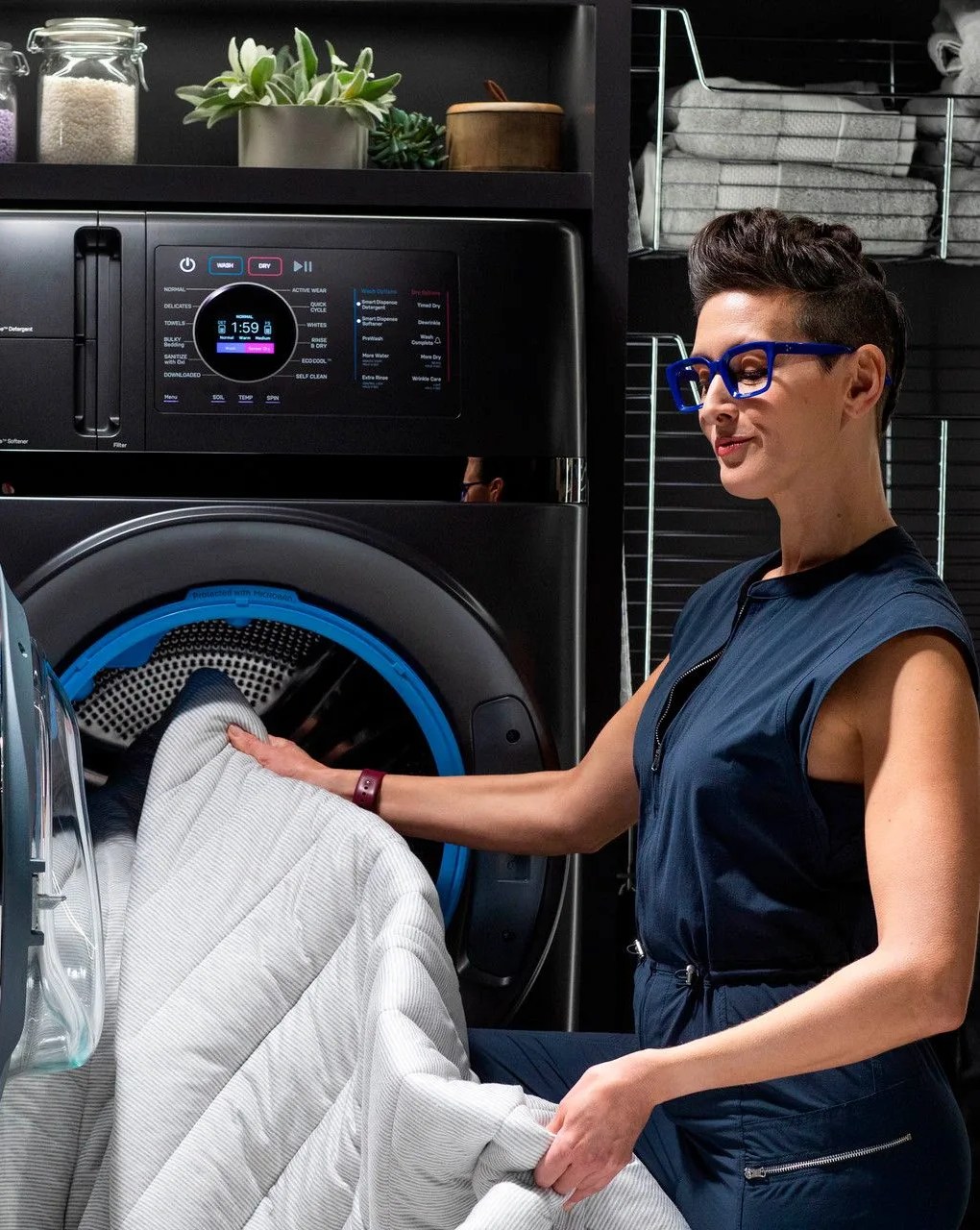 woman loading bedding into ge profile energy star washer dryer