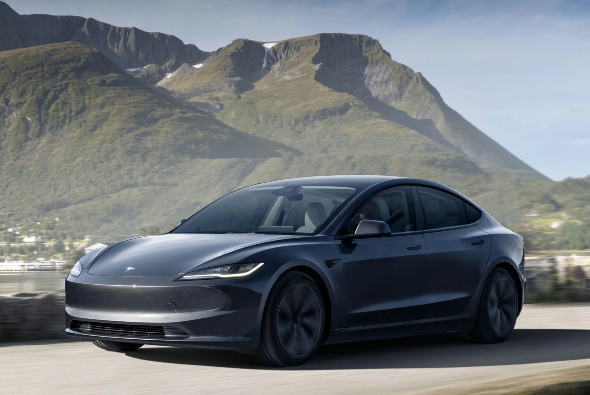 tesla model 3 2024 in gray on a road in front of a mountain