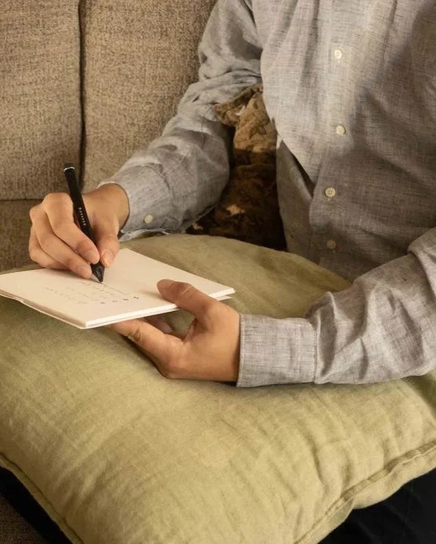 a person writing on a book using a nuwa pen