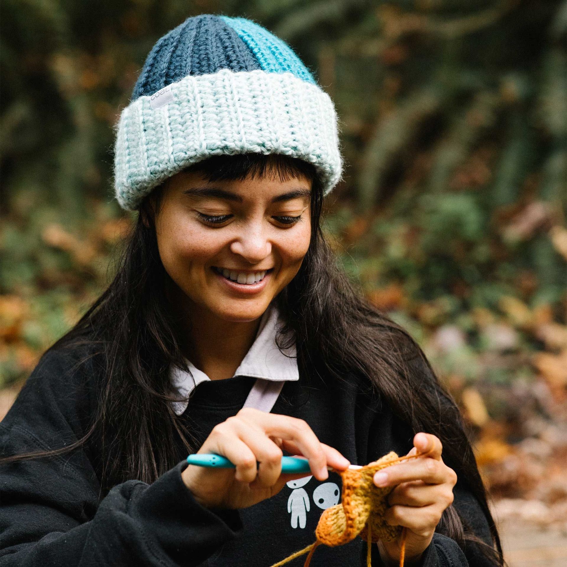 a person wearing a hat and crocheting