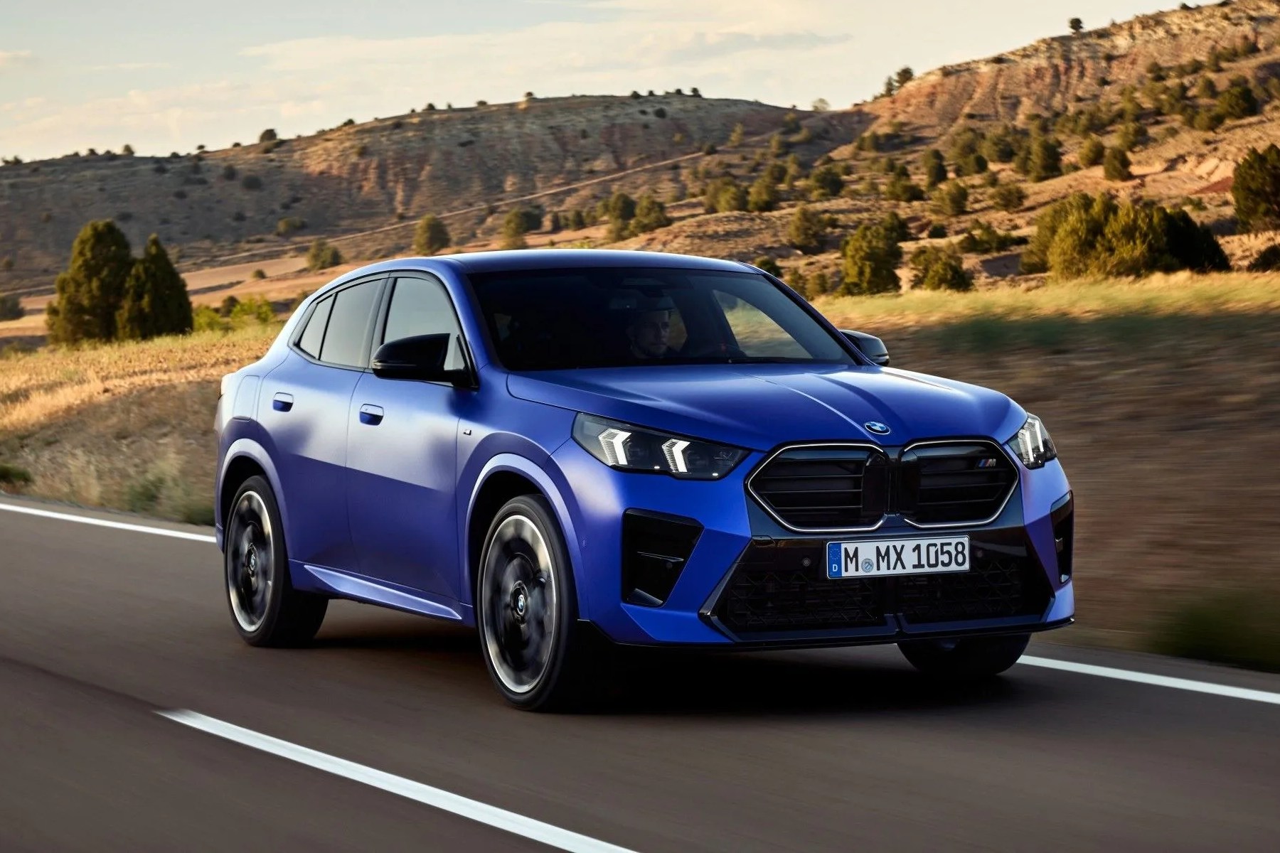 a blue car driving on a road