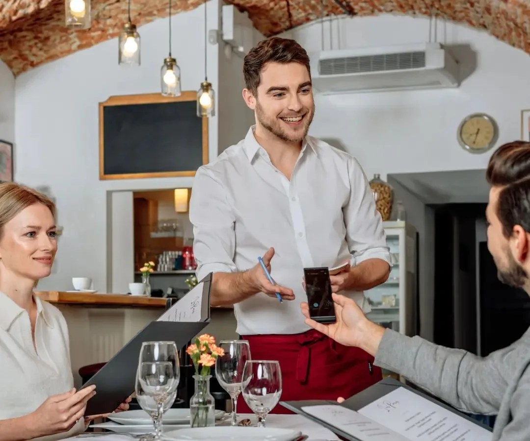 two people using the vasco translator v4 universal translator with 108 languages to talk with the waiter