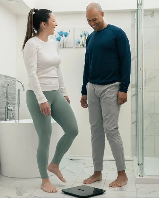 a man and a woman standing to wyze scale x