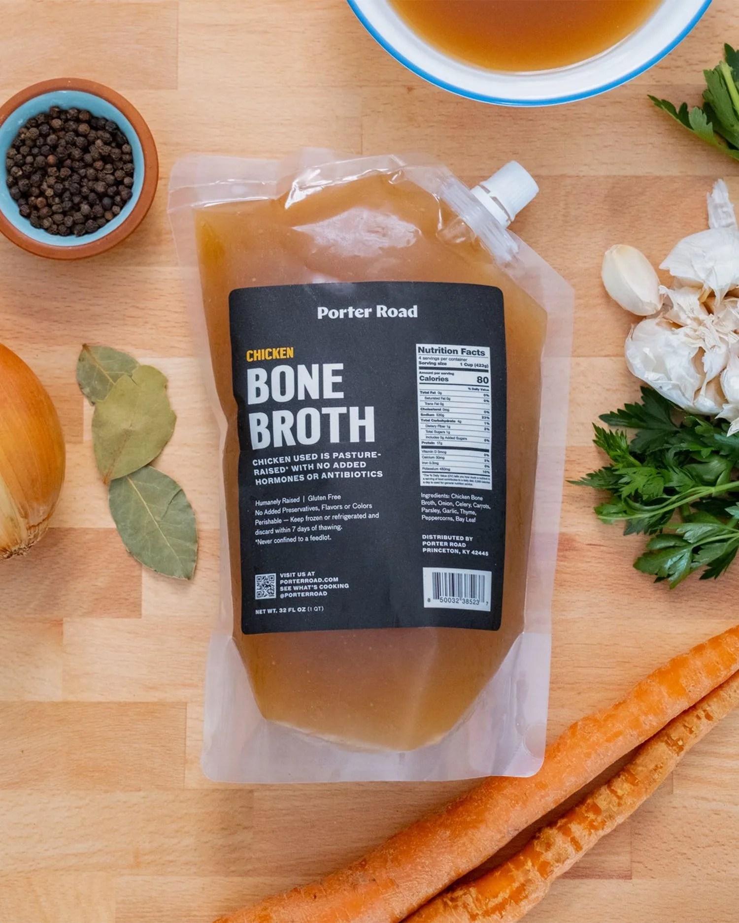 a bag of bone broth on a table with veggies