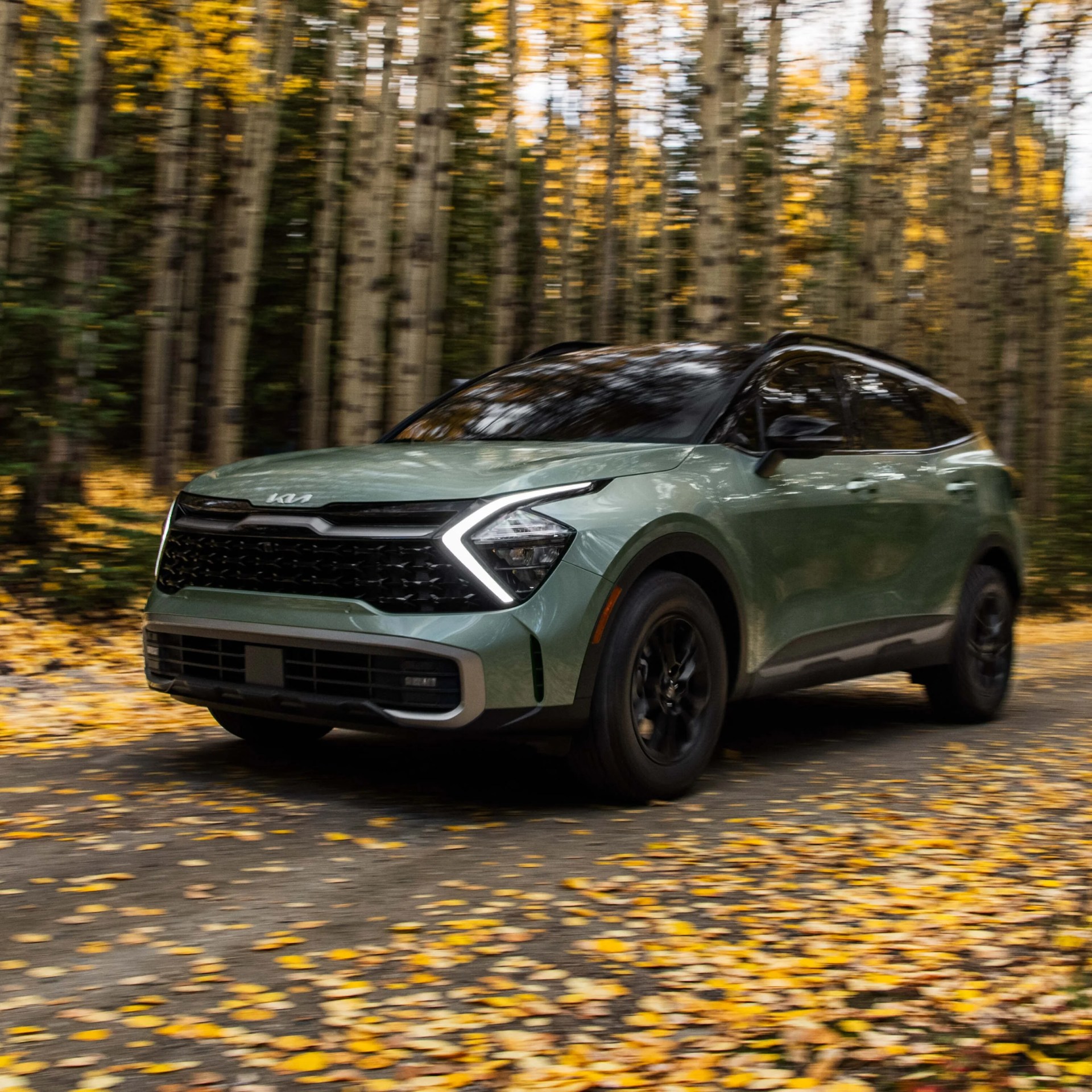 Kia Sportage X-Pro driving in fall