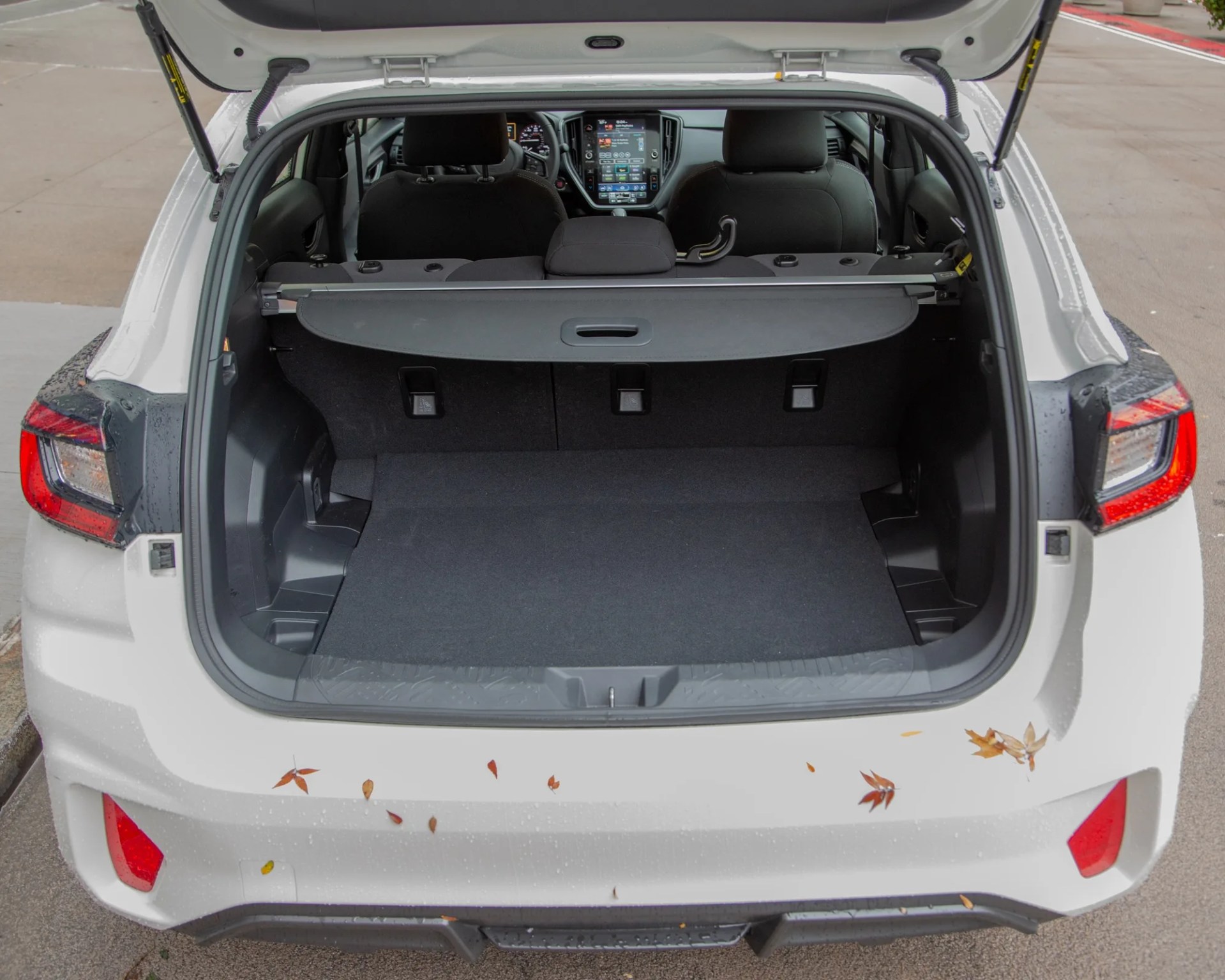 the open rear hatch of a white subaru impreza rs hatchback