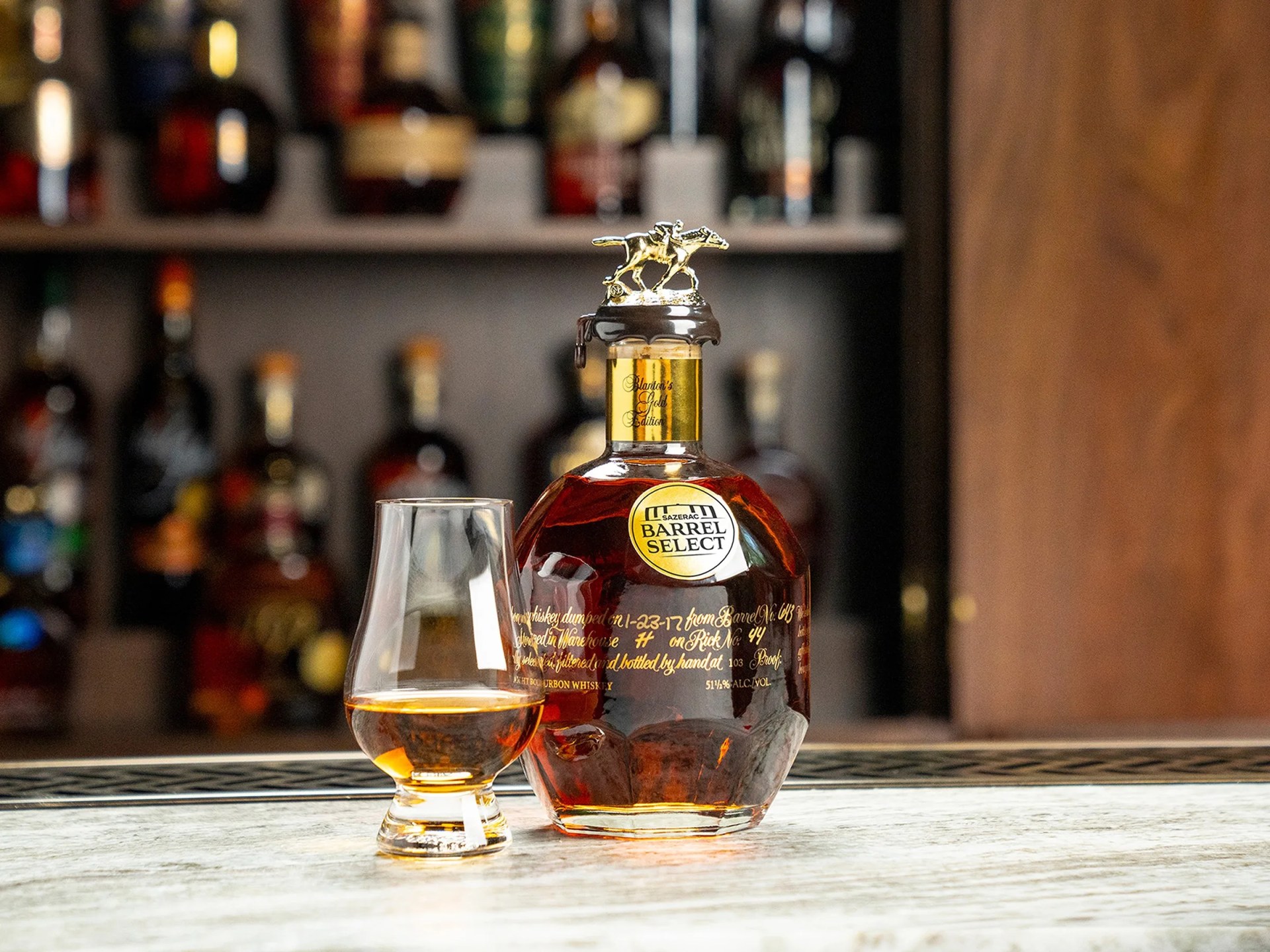 bottle and glass of bourbon on a bar