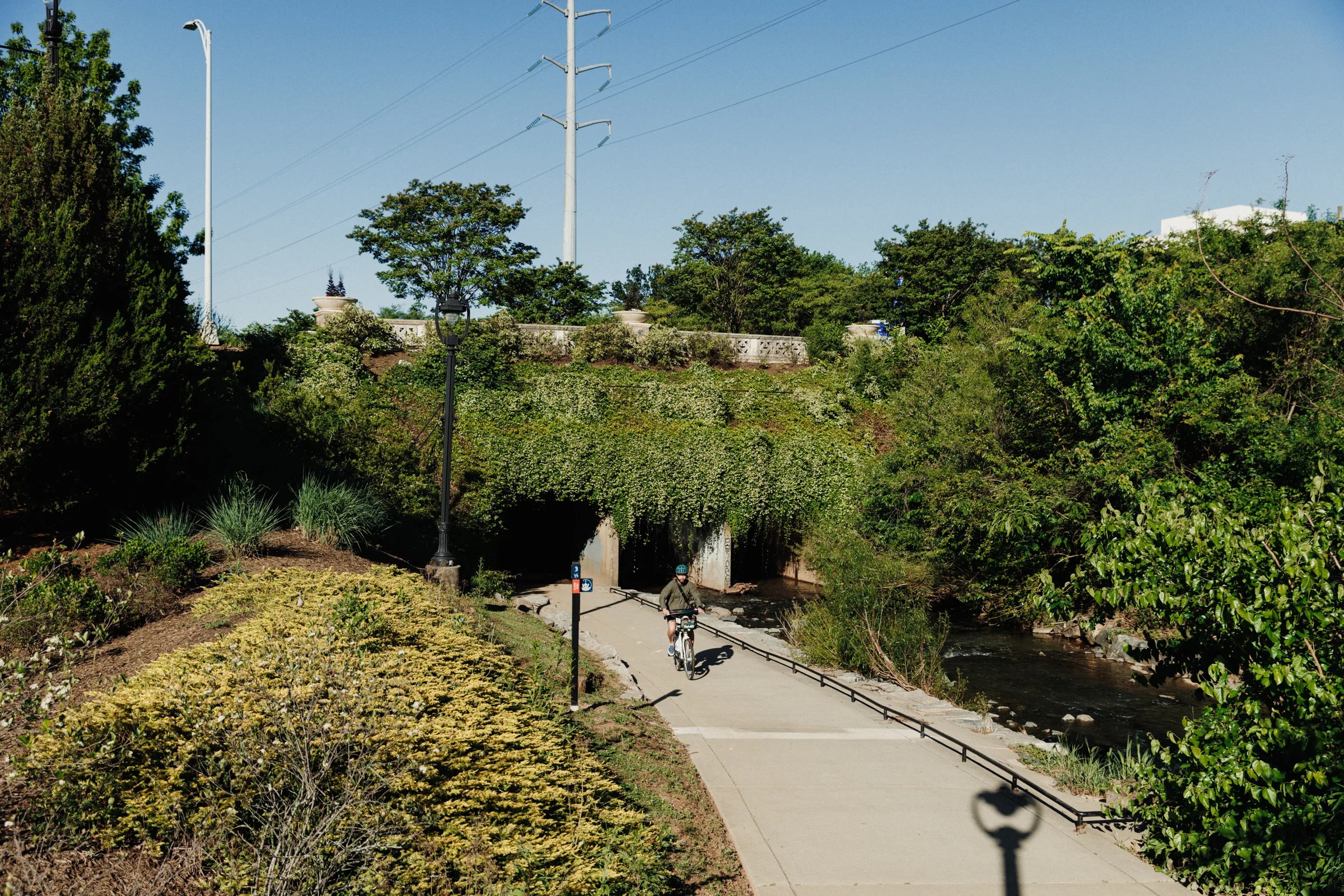 person biking underneath bridge