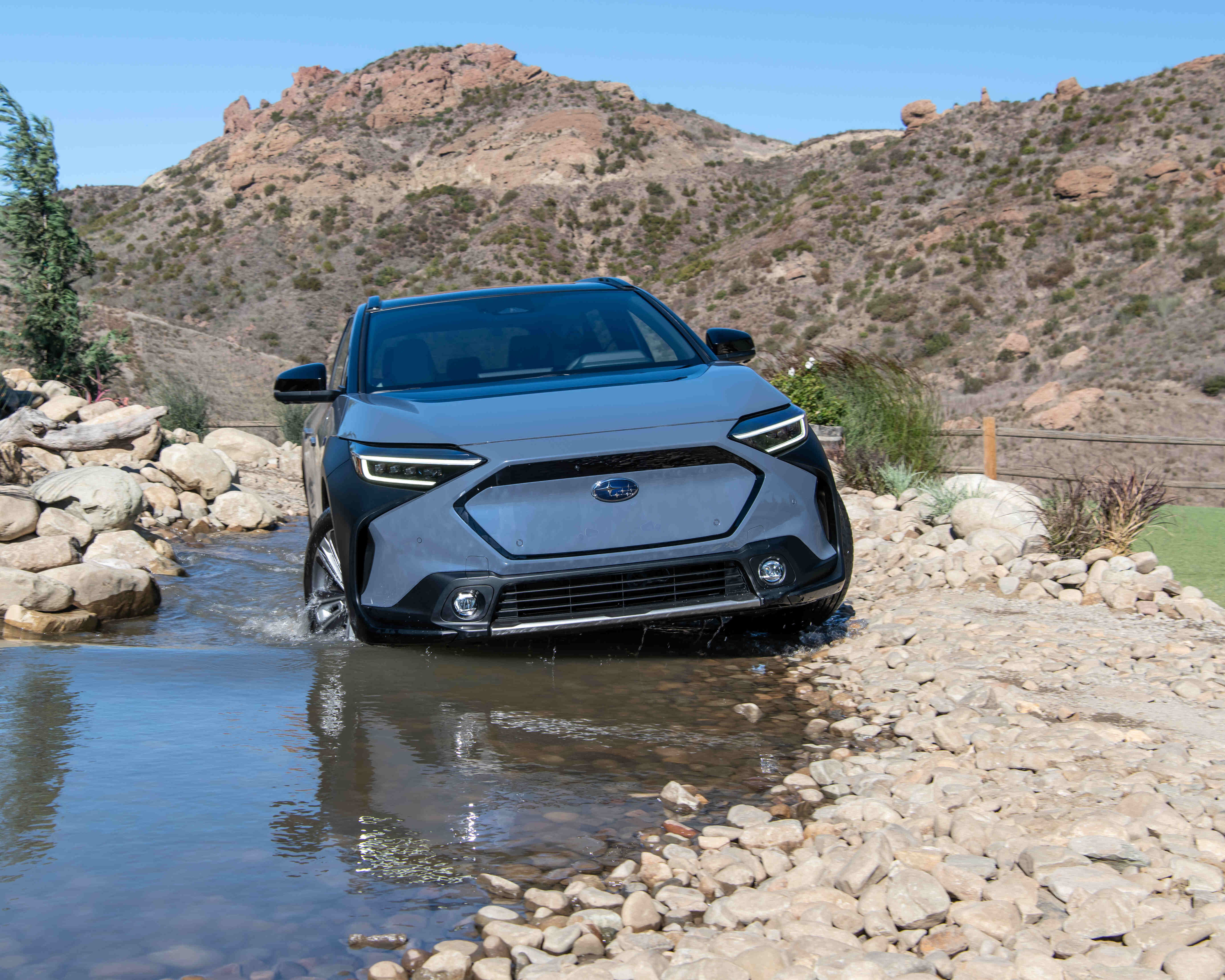 Subaru Solterra driving in a shallow river