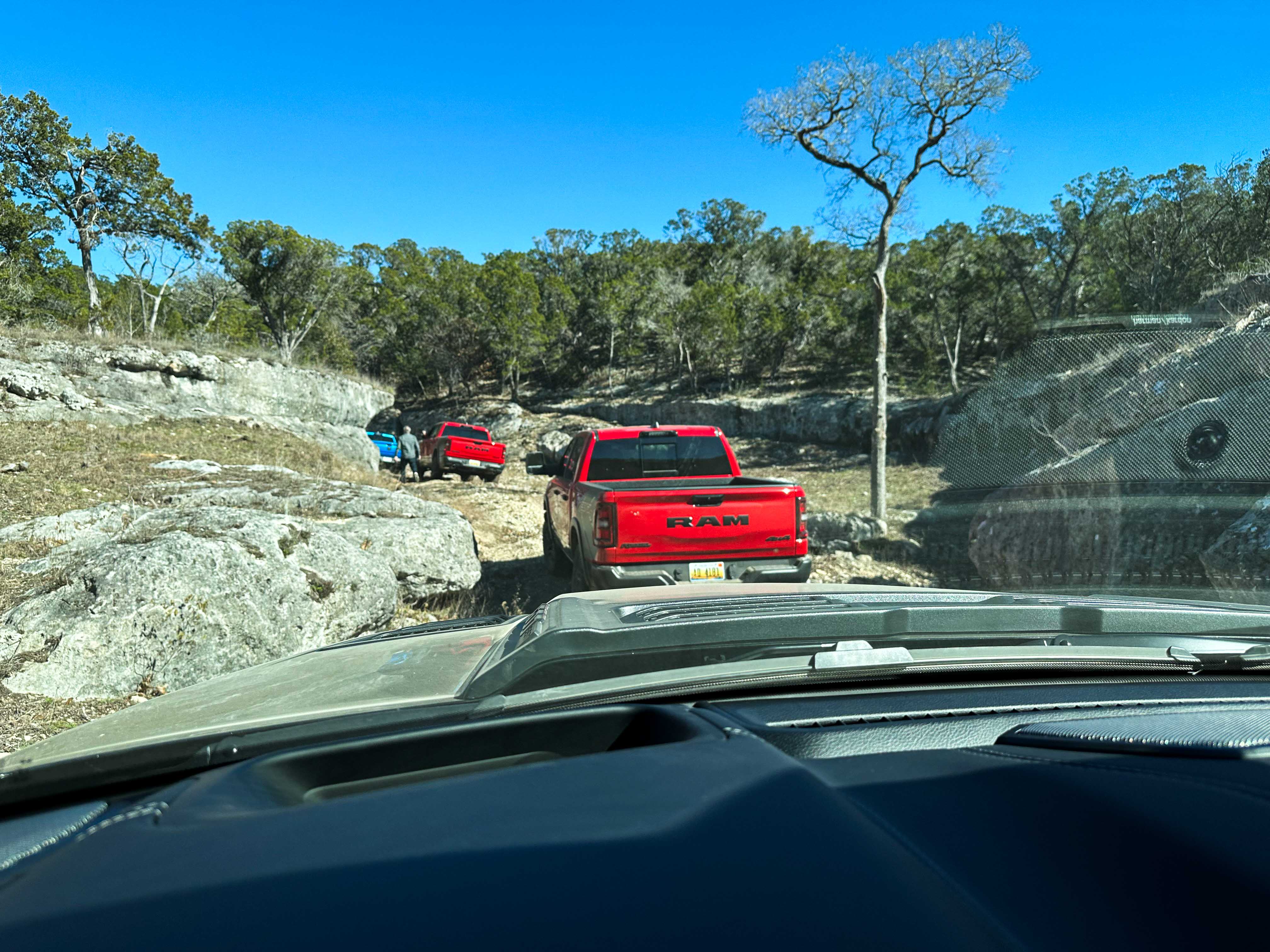 Line of Ram 1500 trucks off roading on hill