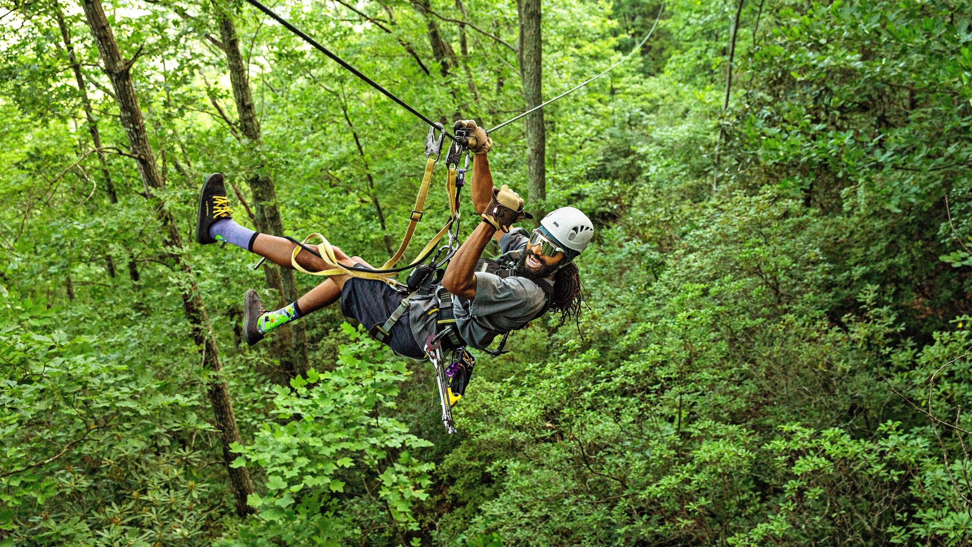 man zip lining down the gorge in saluda