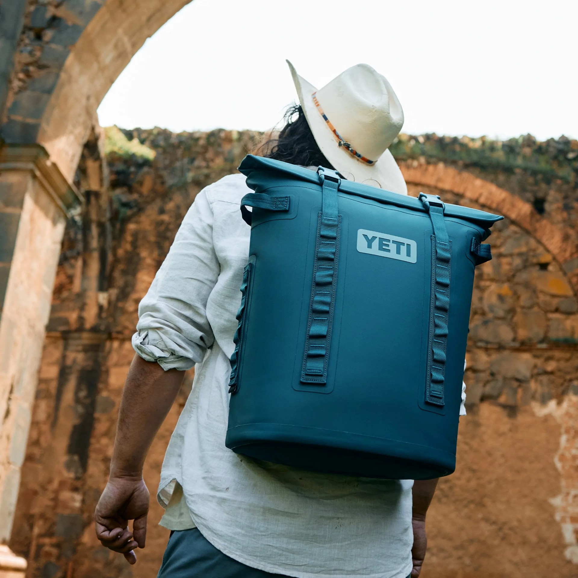 man walking with Yeti cooler strapped to back