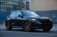 front three quarter view of a dark blue BMW X5 parked on a city street