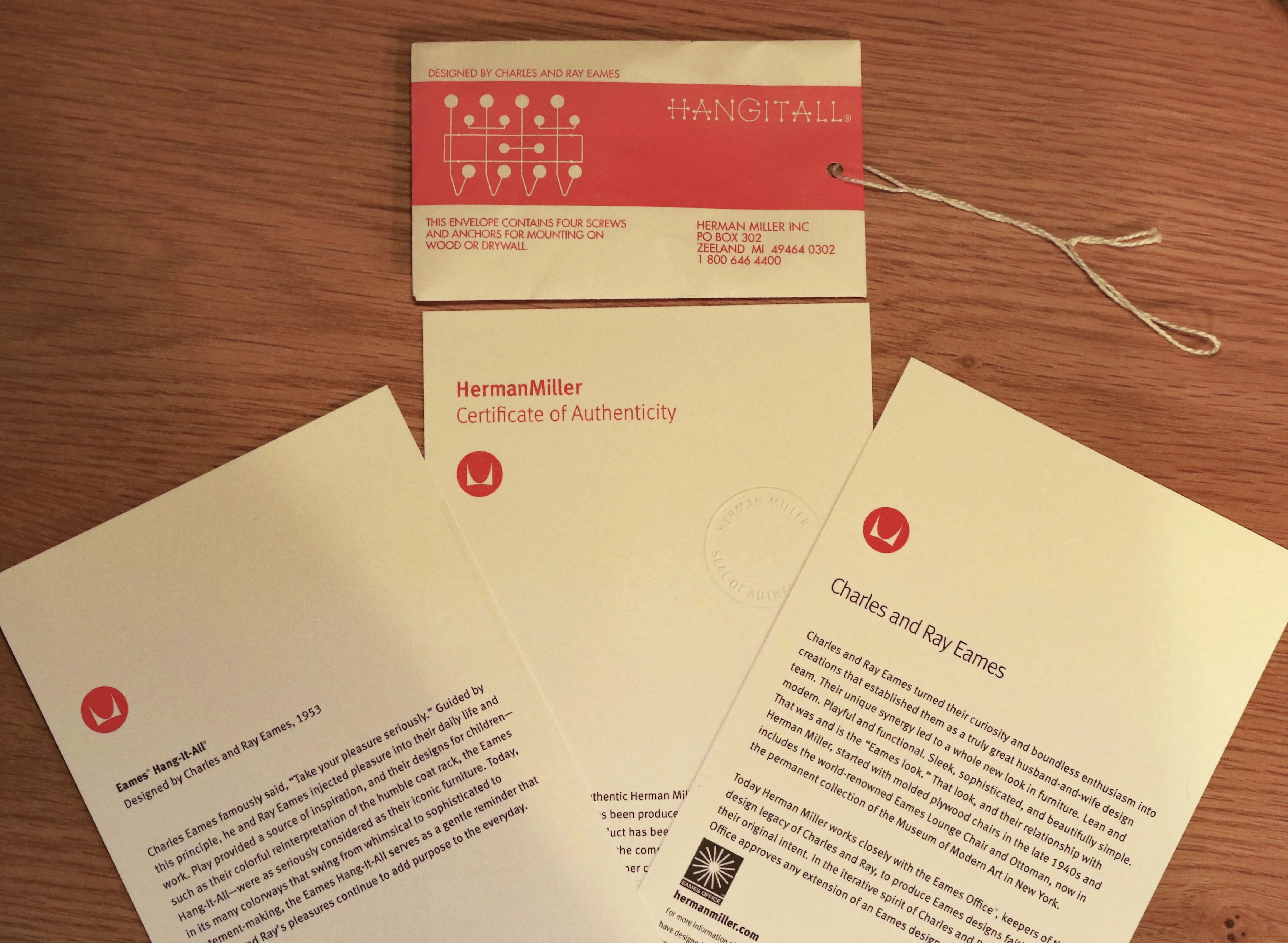 three pieces of paper on a wooden table showing herman miller authenticity