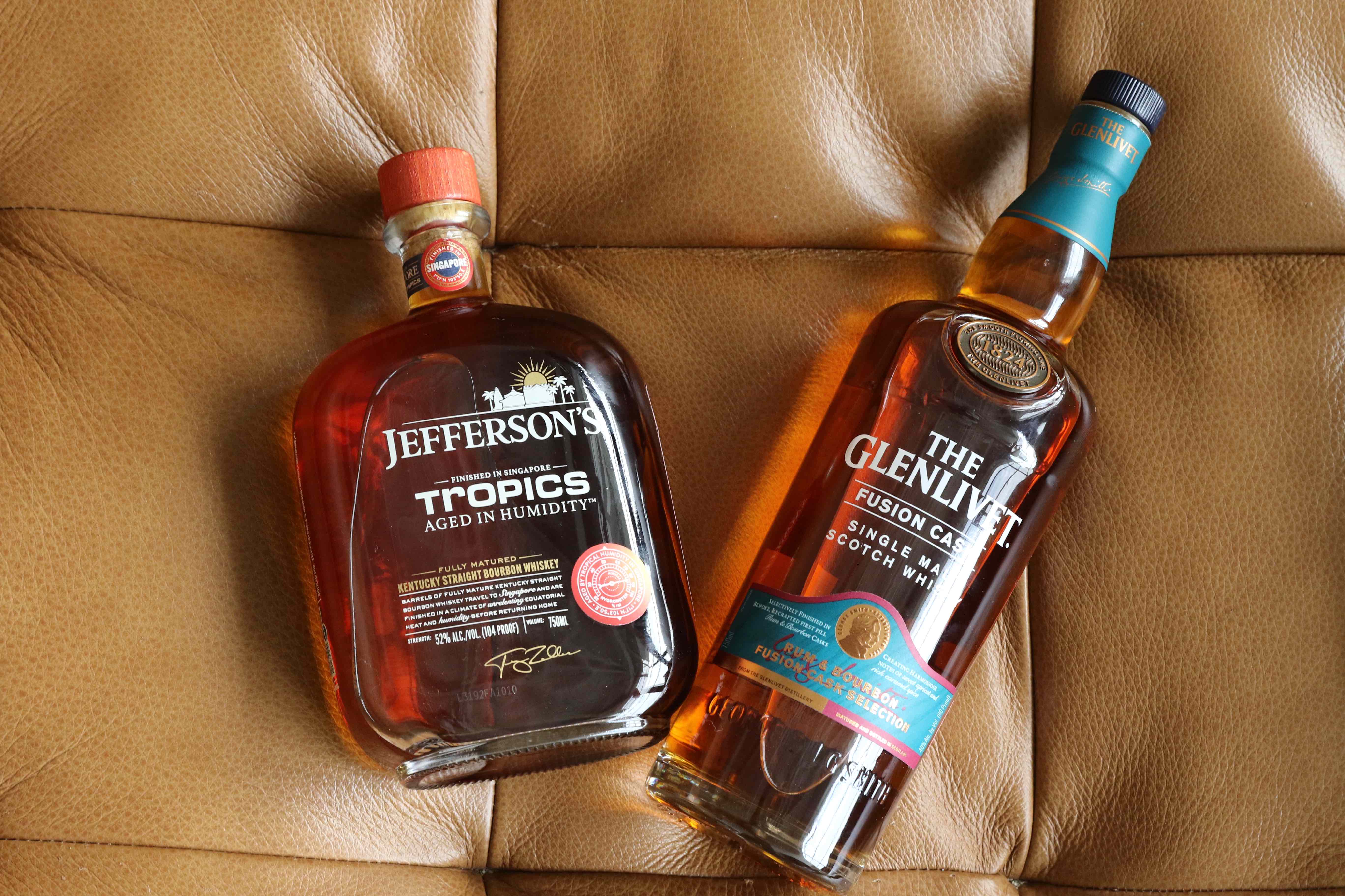 two bottles of alcohol on a leather couch