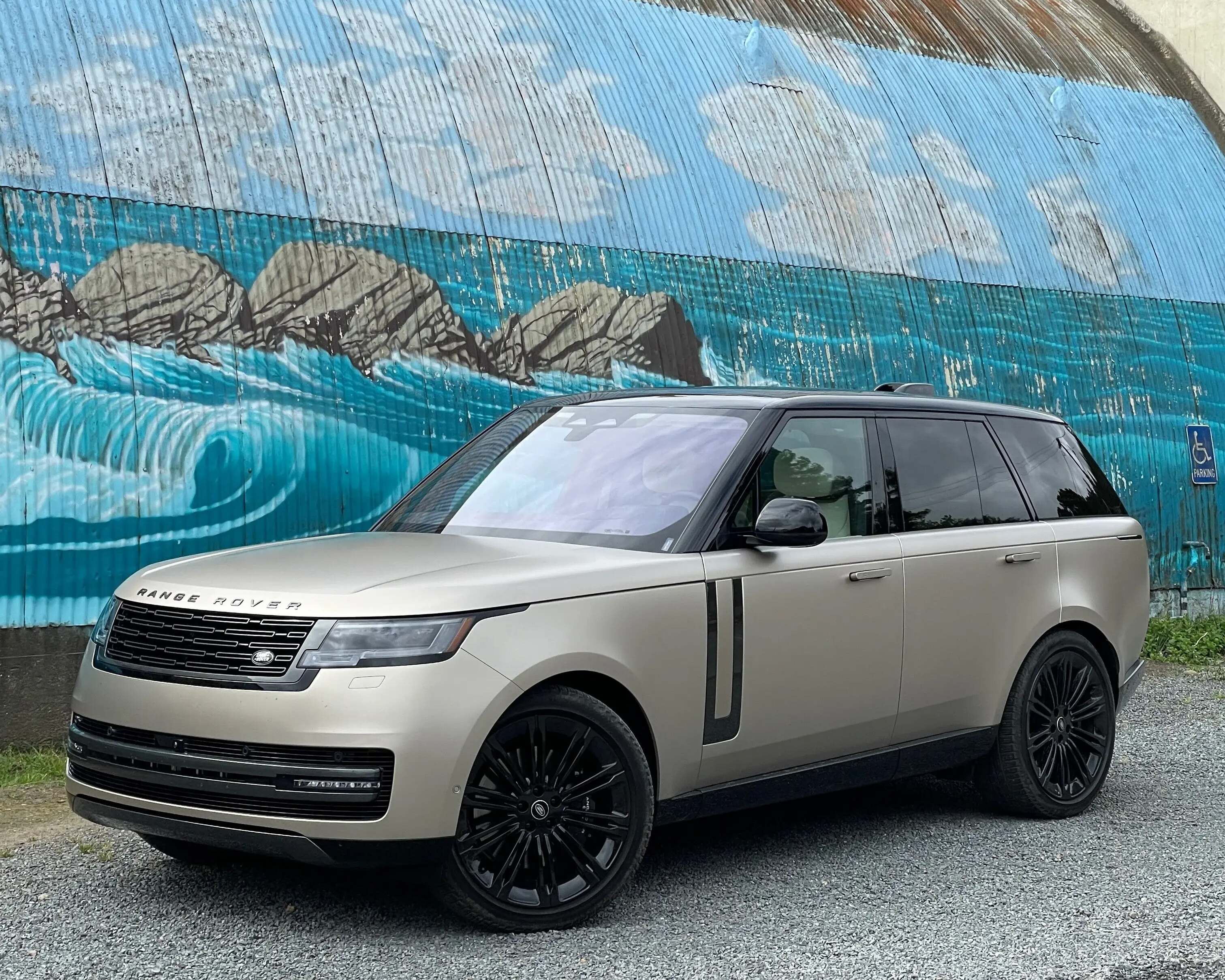 range rover parked in front of silo with mural