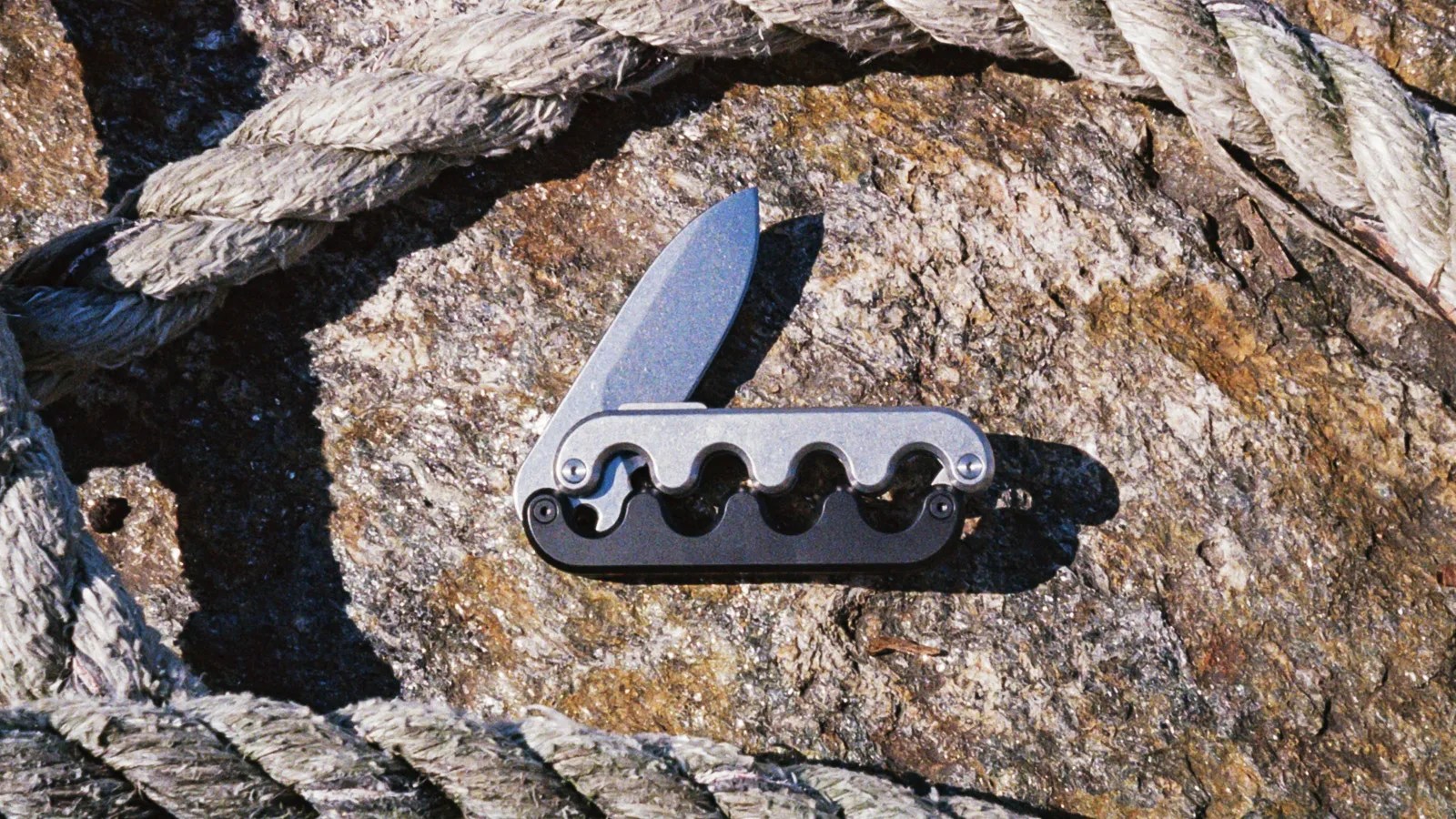 craighill sidewinder knife on dirt background surrounded by a thick rope