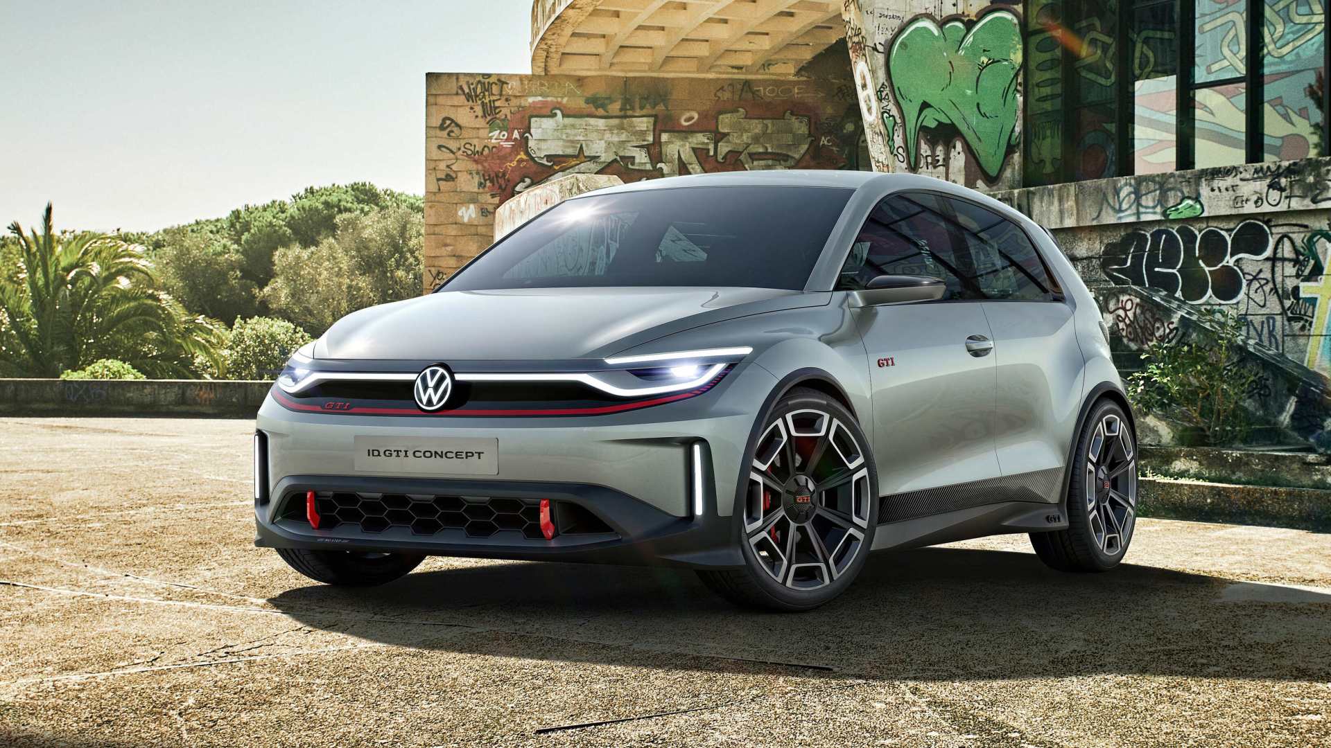 Electric Volkswagen Gofl GTI parked in front of a fancy house with graffiti