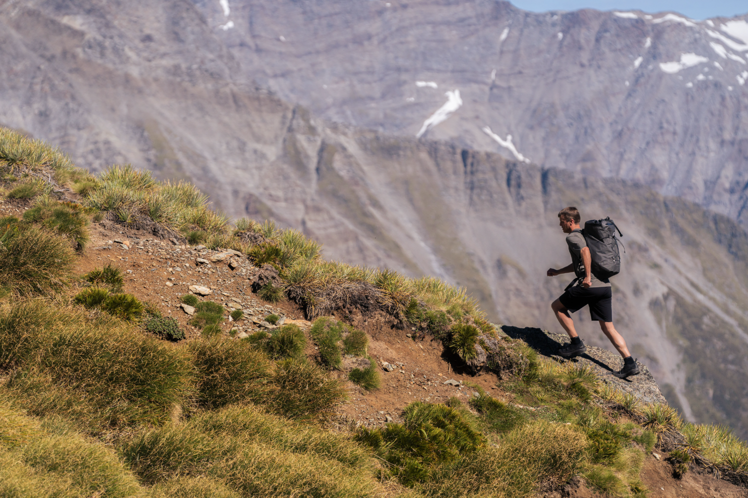 a man wearing the arc'teryx kragg approach shoe climbing a mountainside