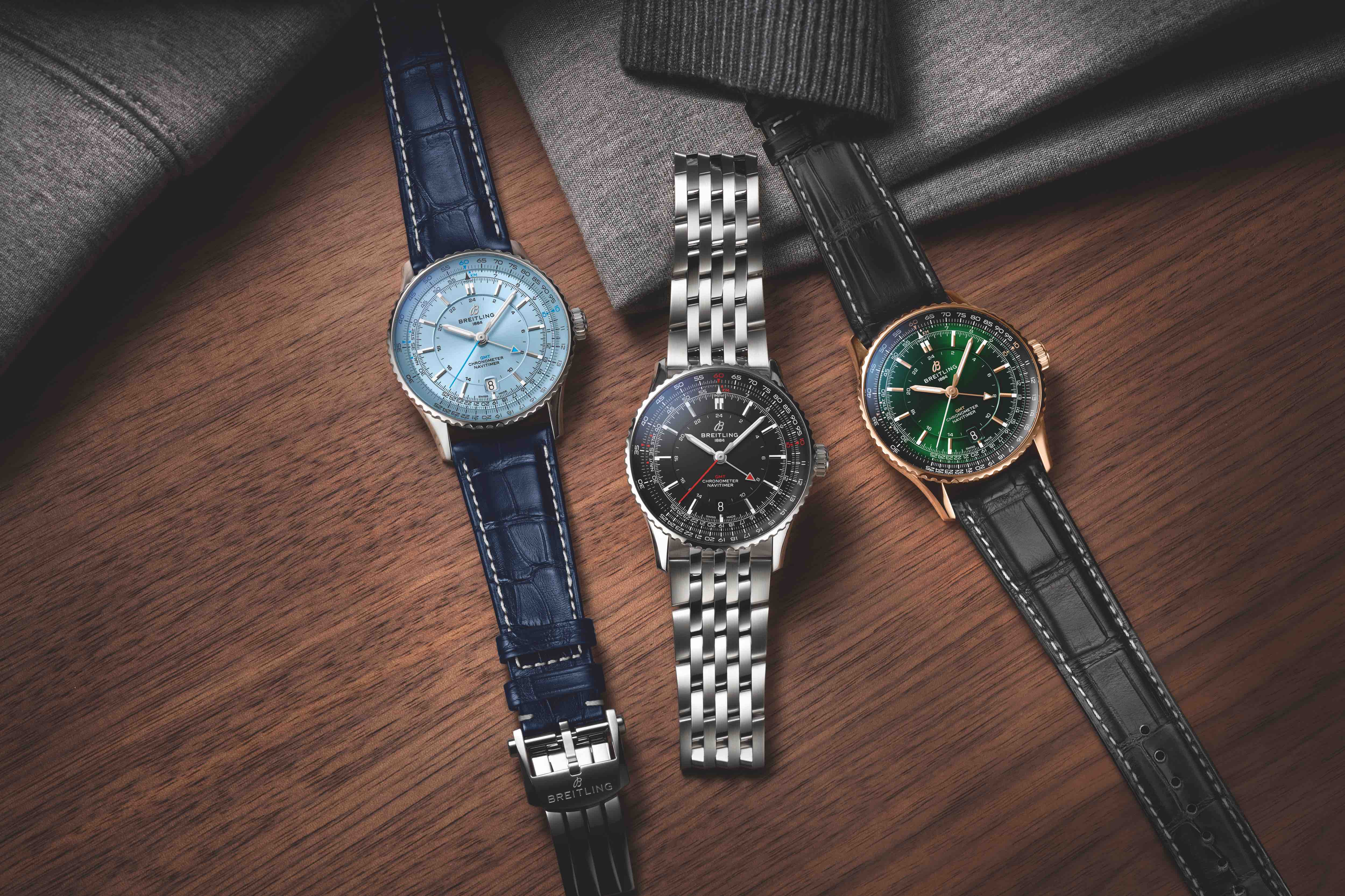 three breitling gmt watches on a table
