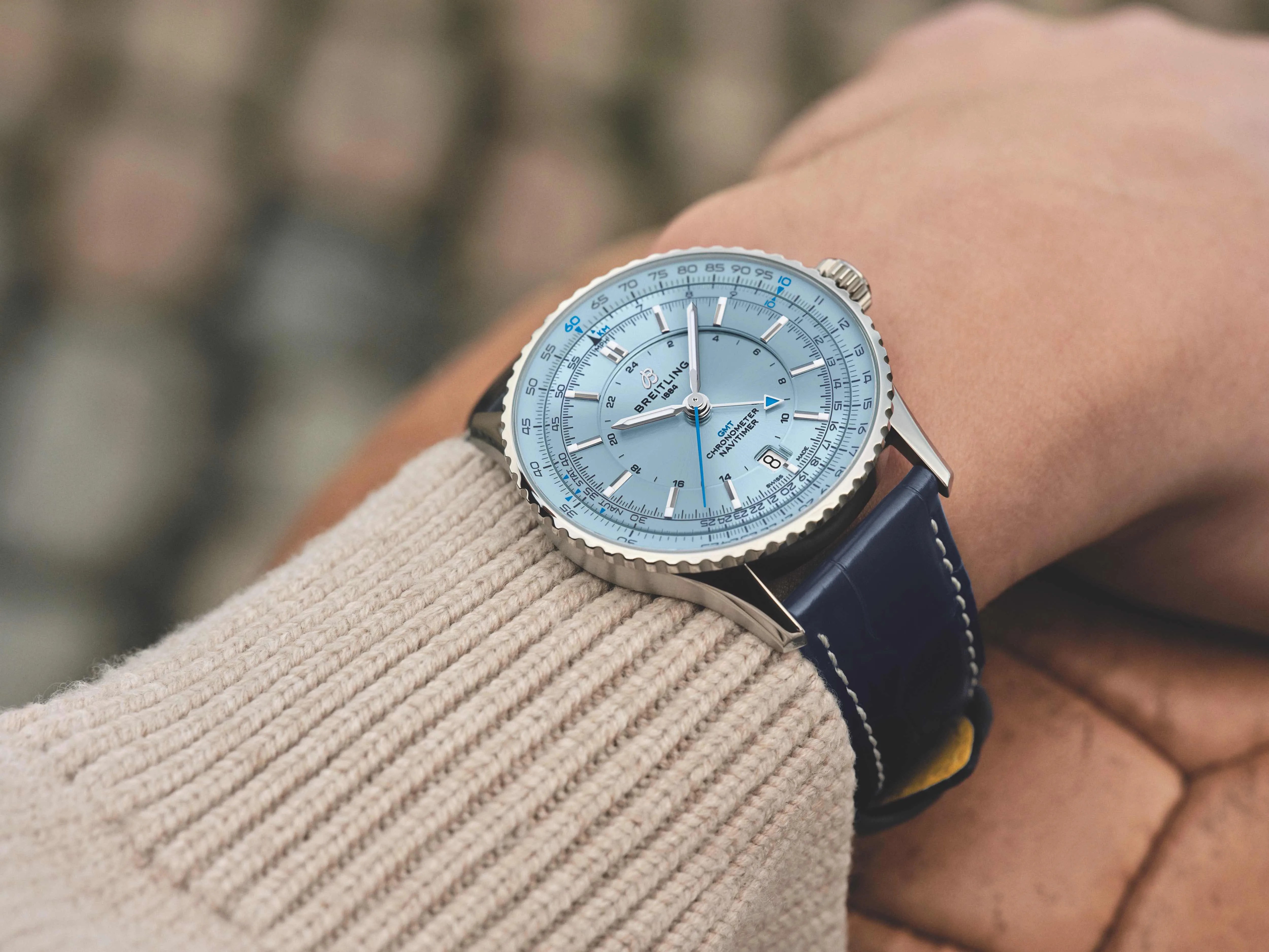 blue breitling watch on mans wrist