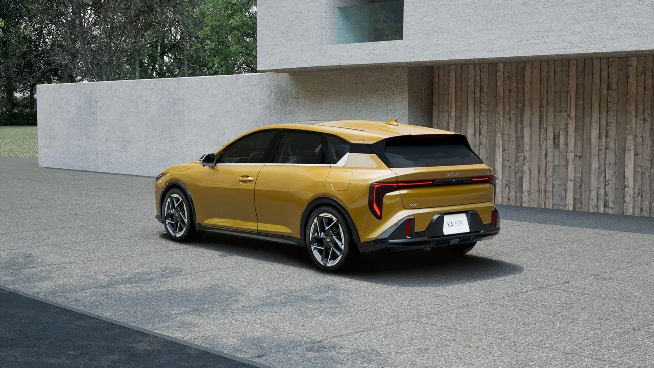 kia hatchback seen from the rear in front of a house