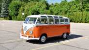 Old VW bus in a parking lot with trees in the background