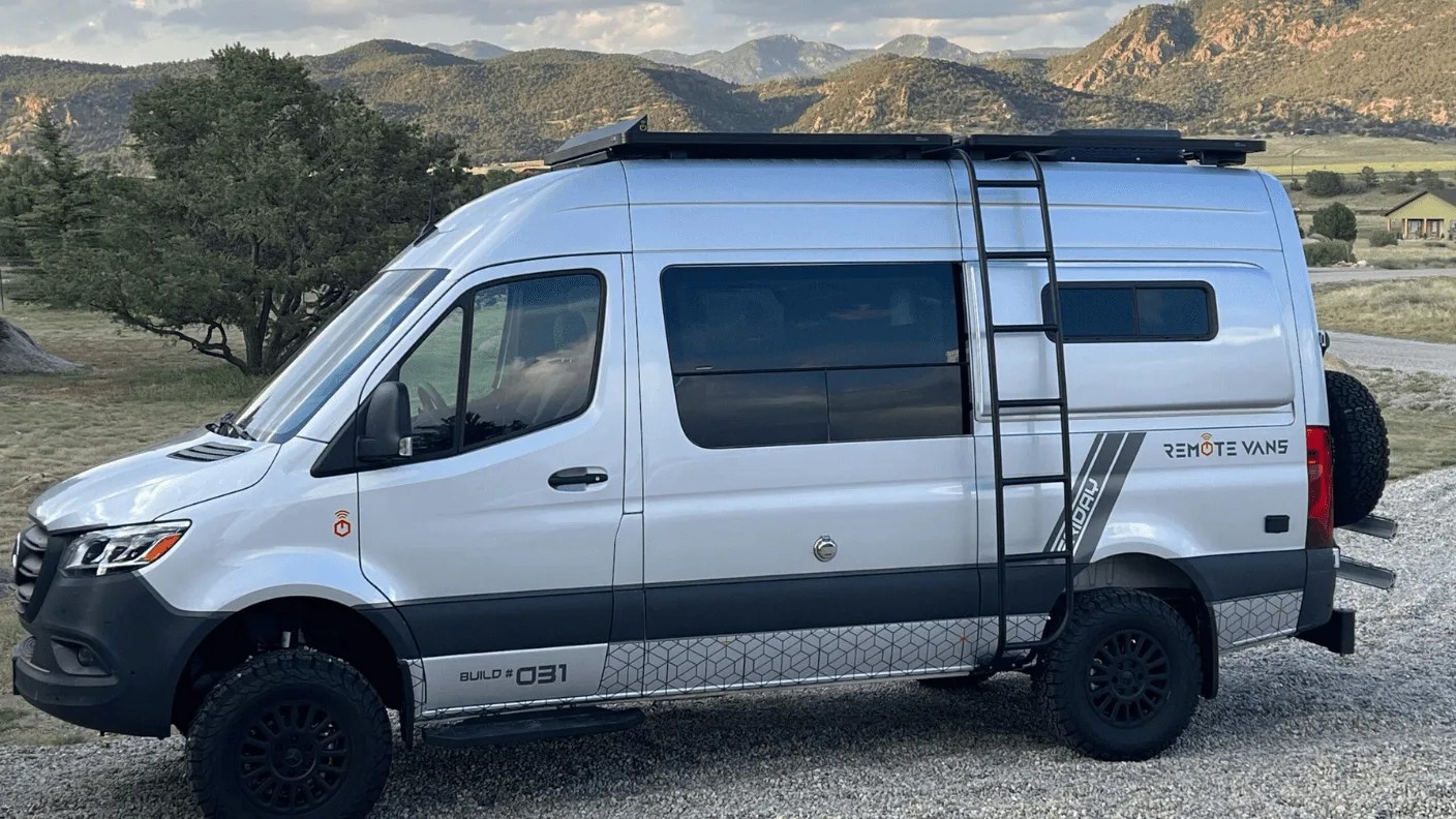 side view of a camper van in front of mountains